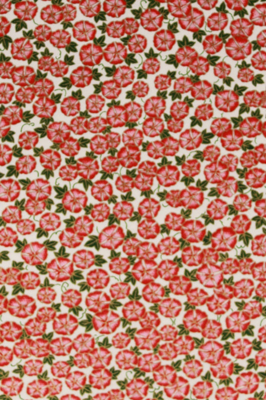 Patterned chiyogami paper with red floral design on a pink background