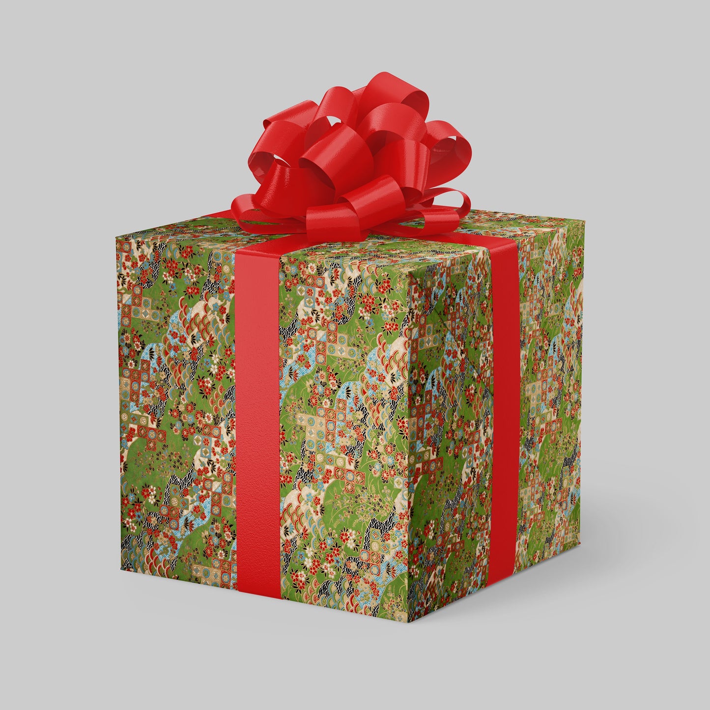 Gift box wrapped with chiyogami paper with patterned wrapping paper and a red bow on a gray background