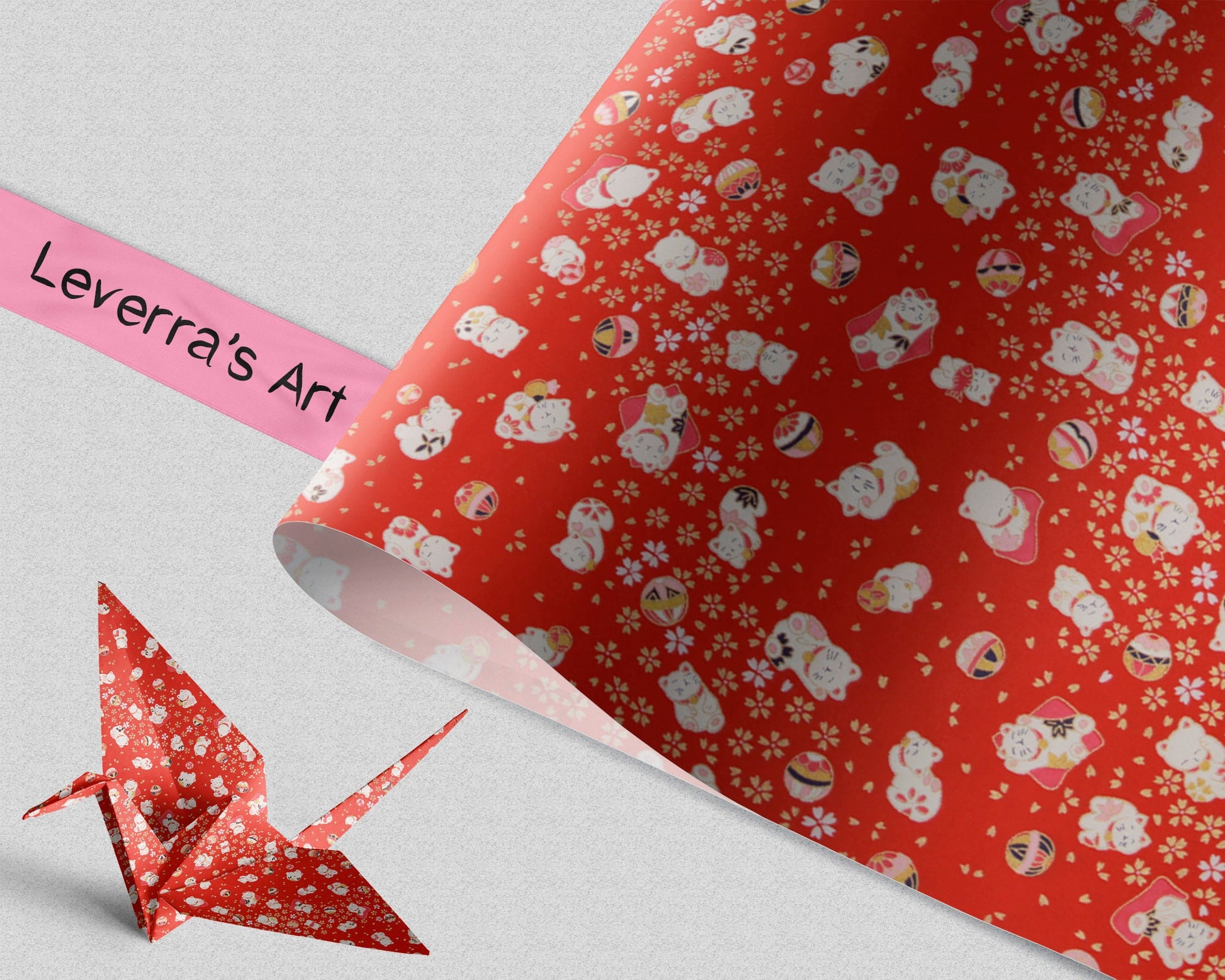 Roll of red chiyogami paper with white cat pattern and 'Leverra's Art' branding and folded paper crane.
