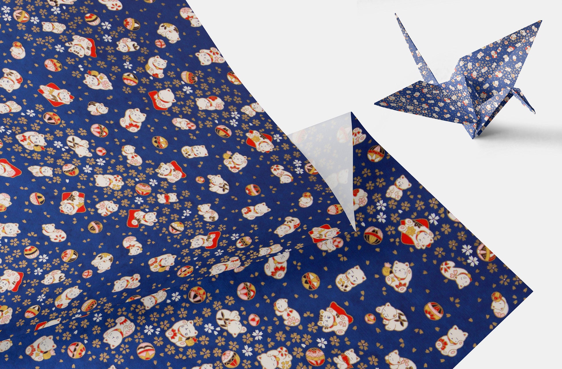 Blue wrapping chiyogami paper with cartoon character pattern and a folded paper crane on a white background