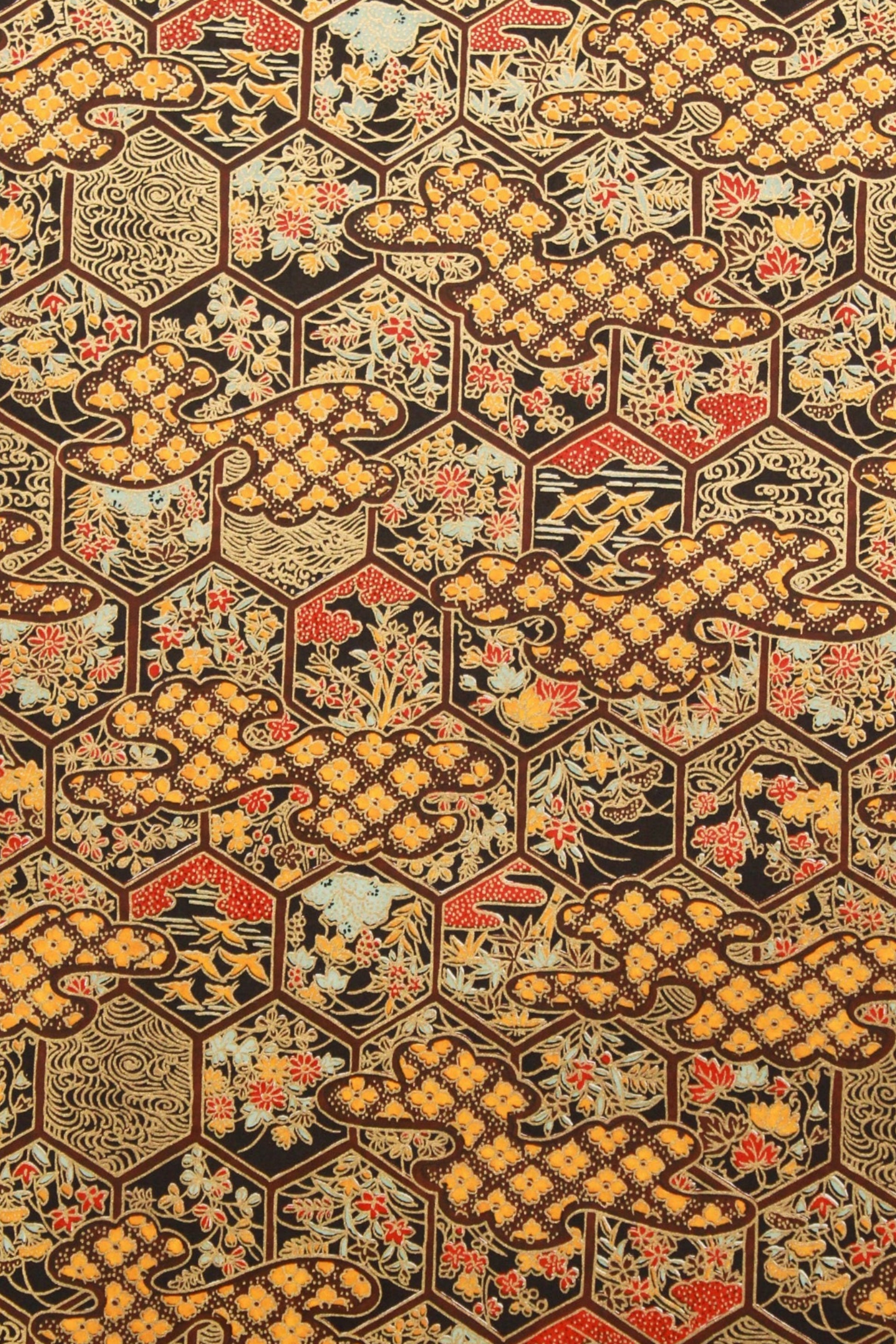 Chiyogami paper with hexagonal pattern with geometric shapes in brown, orange, and red on a textured background