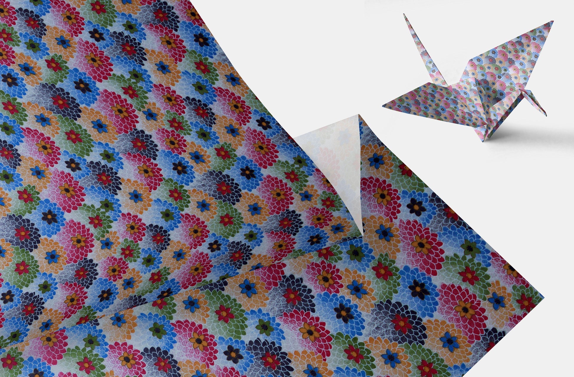 Colorful floral-patterned chiyogami paper with a folded paper crane on a white background