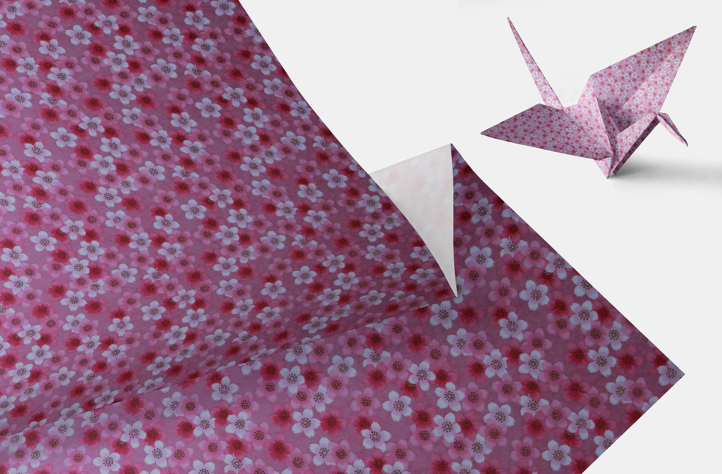 Floral-patterned chiyogami paper with a folded paper crane on a white background