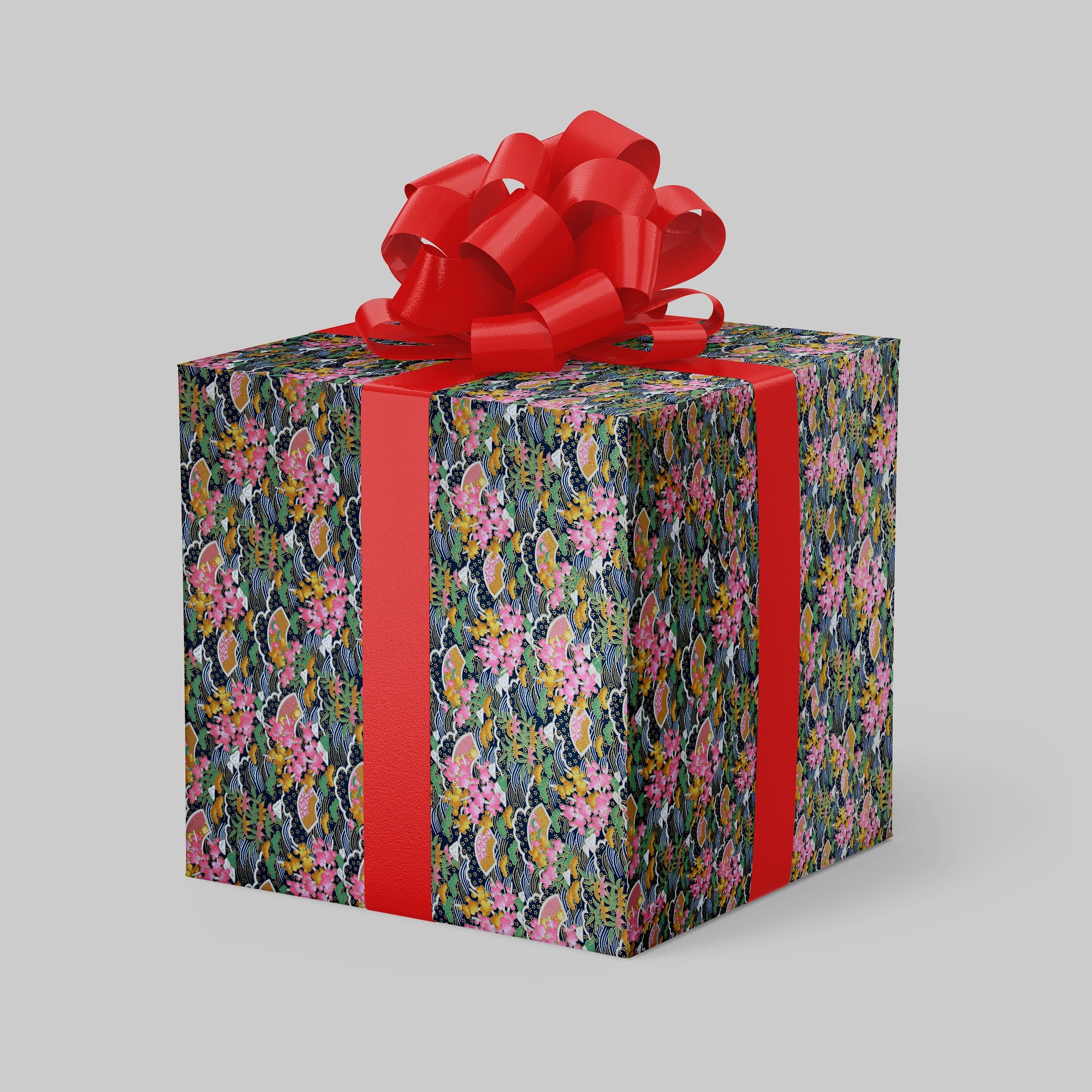 Floral-patterned gift box wrapped with chiyogami paper with a red ribbon and bow on a gray background