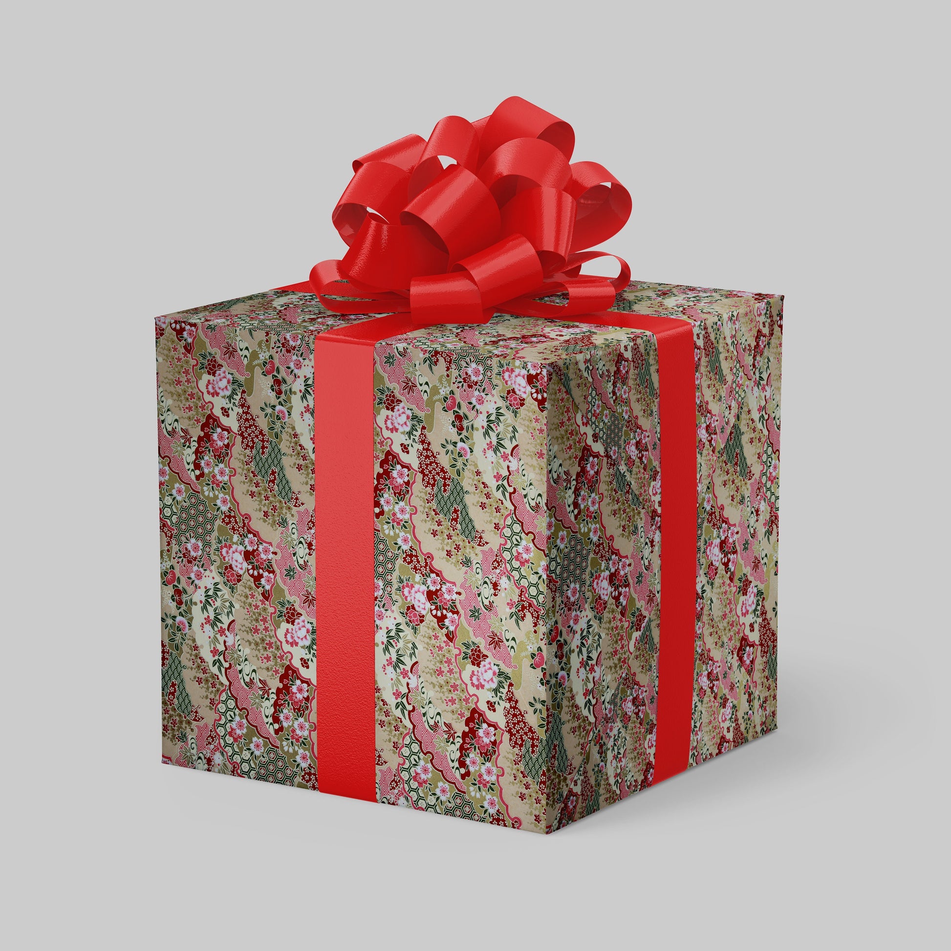 Gift box wrapped with chiyogami paper with floral pattern and red ribbon on a gray background