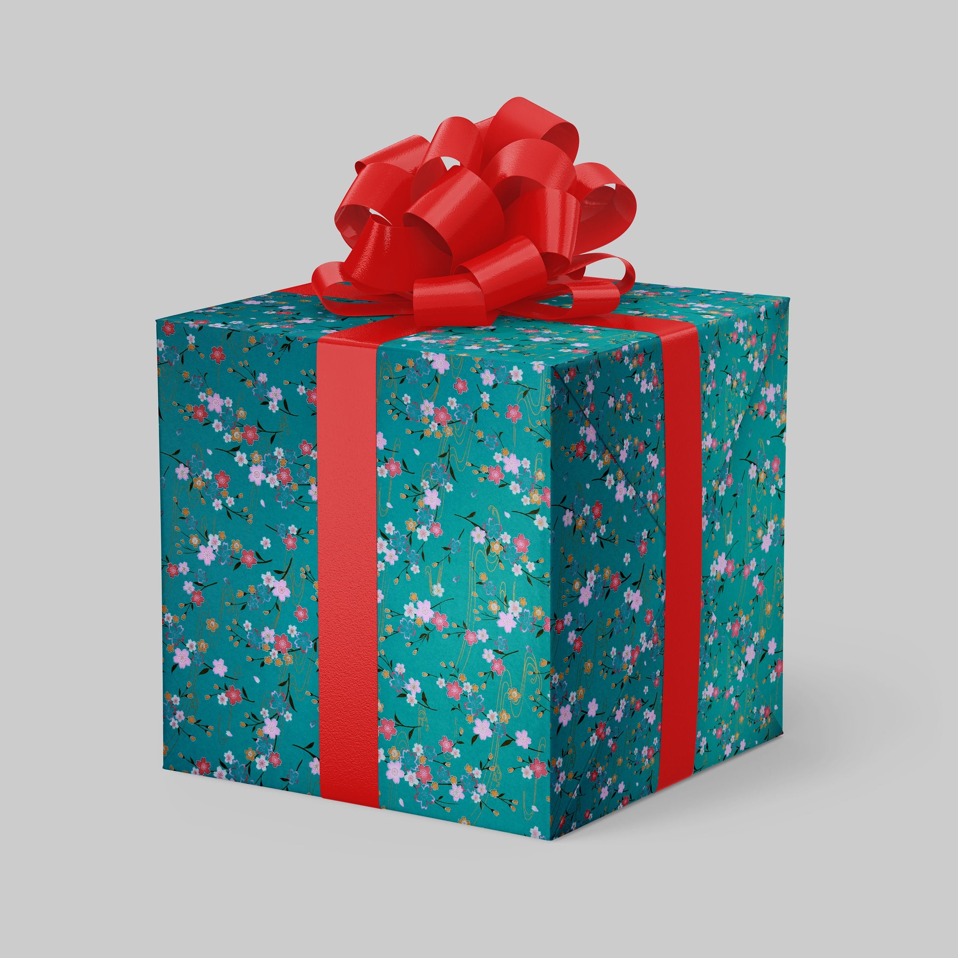Gift box wrapped with chiyogami paper with floral pattern and red ribbon on a gray background