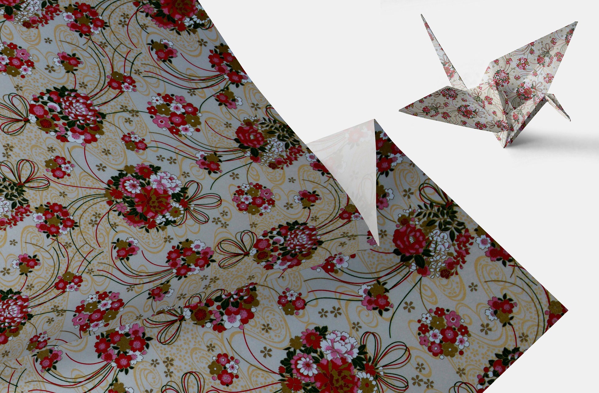 Floral-patterned paper with origami cranes on a white background