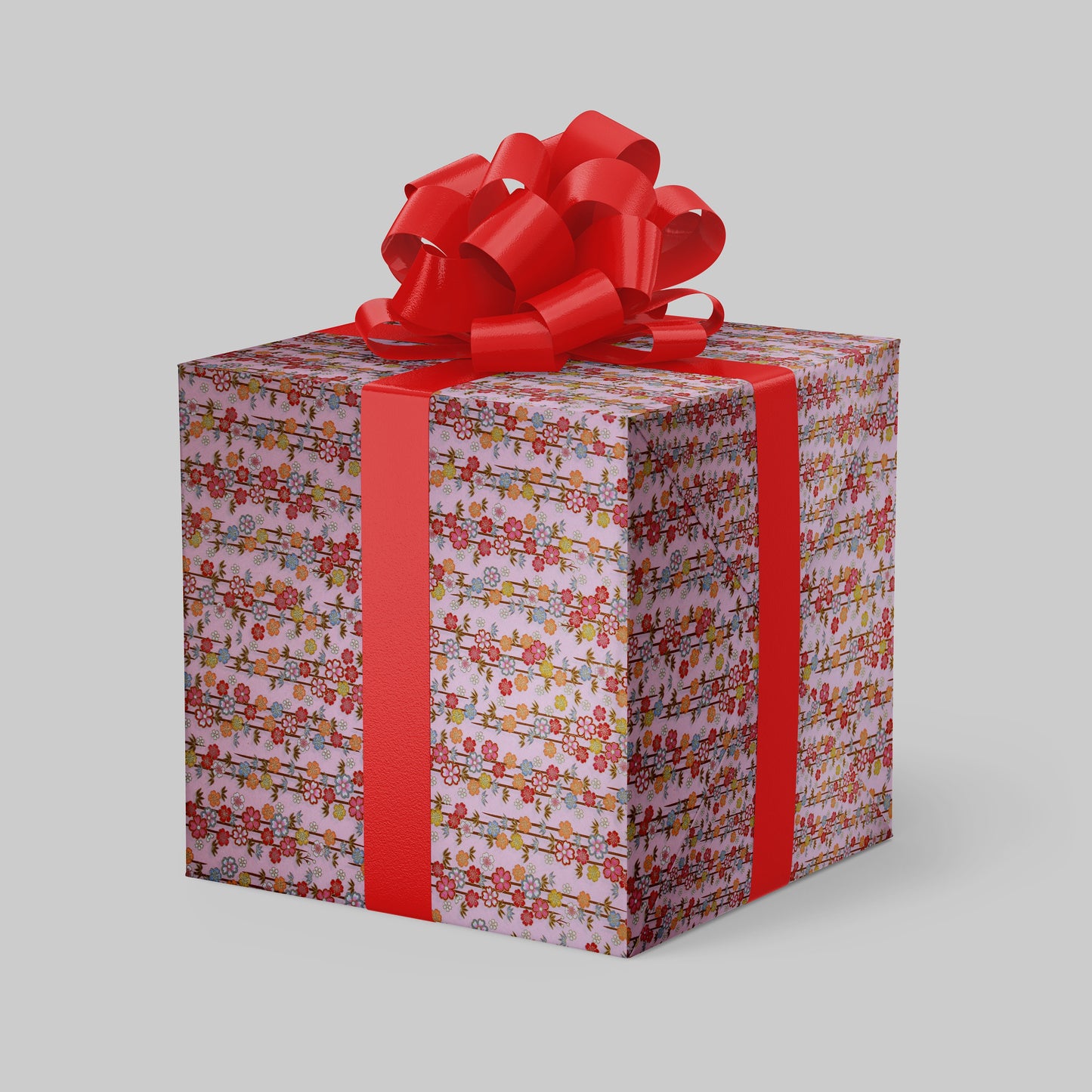 Gift box wrapped with chiyogami paper with colorful pattern and red ribbon on a light gray background