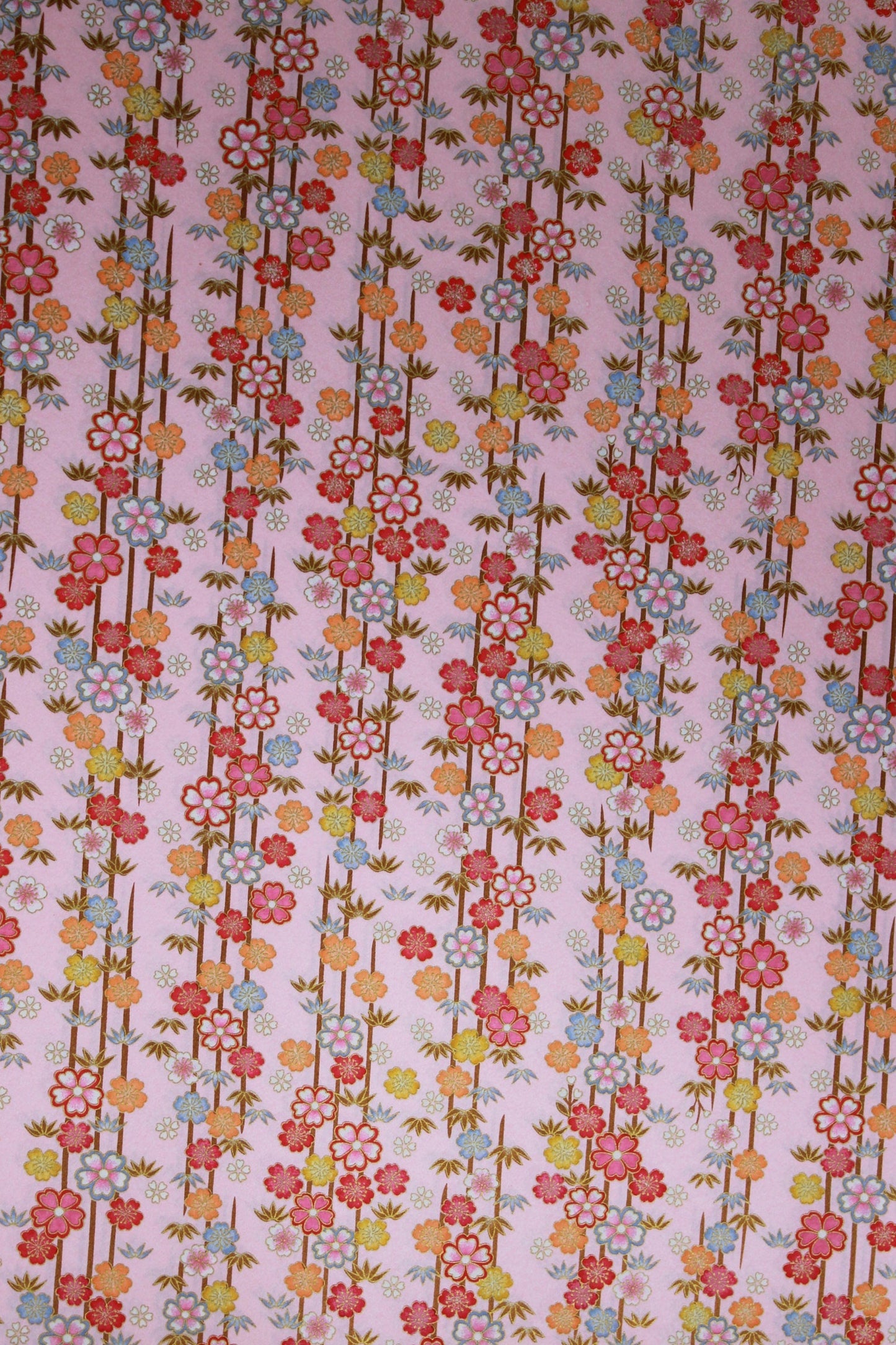 Floral patterned chiyogami paper with small flowers and leaves on a pink background