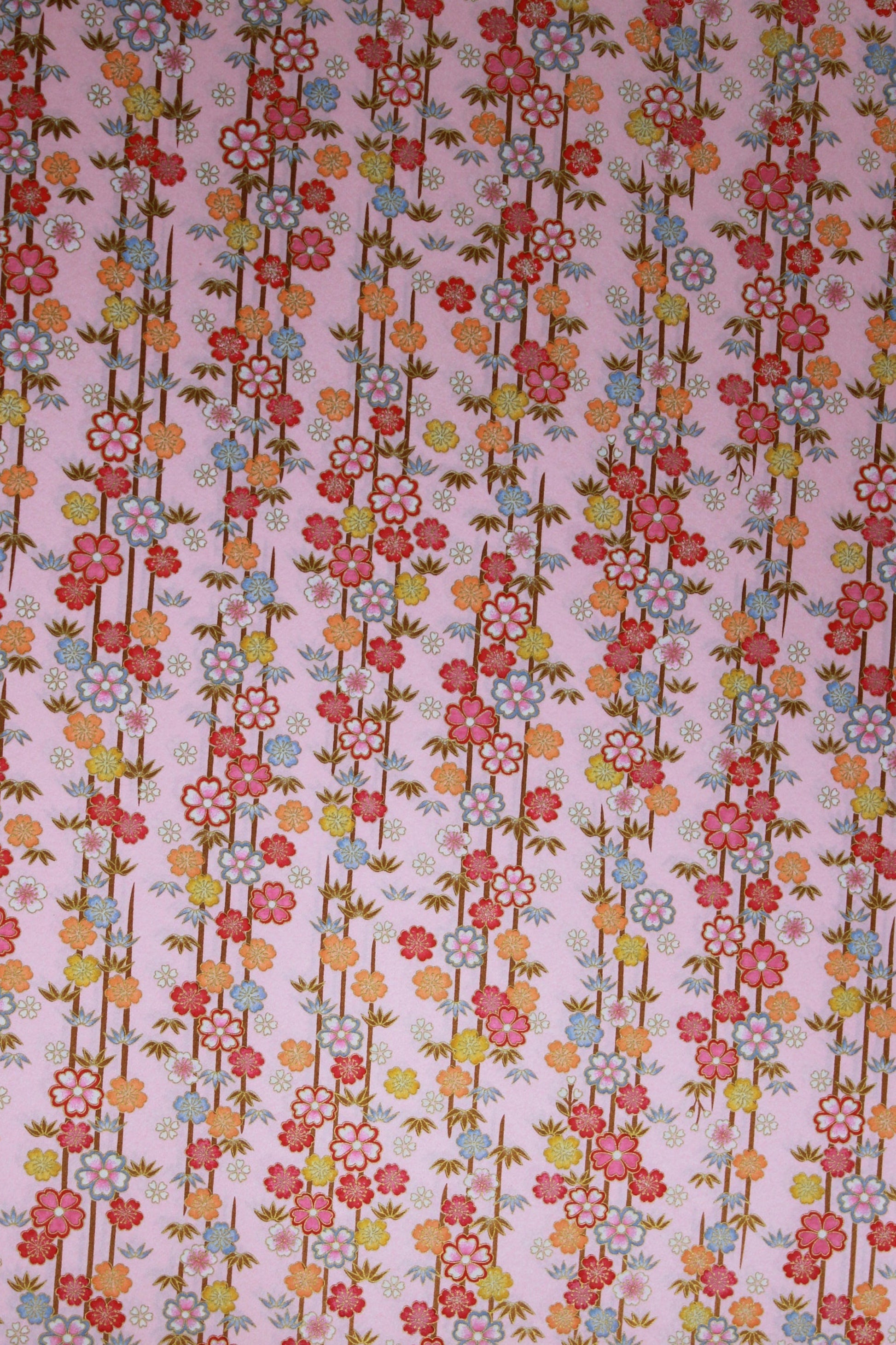 Floral patterned chiyogami paper with small flowers and leaves on a pink background
