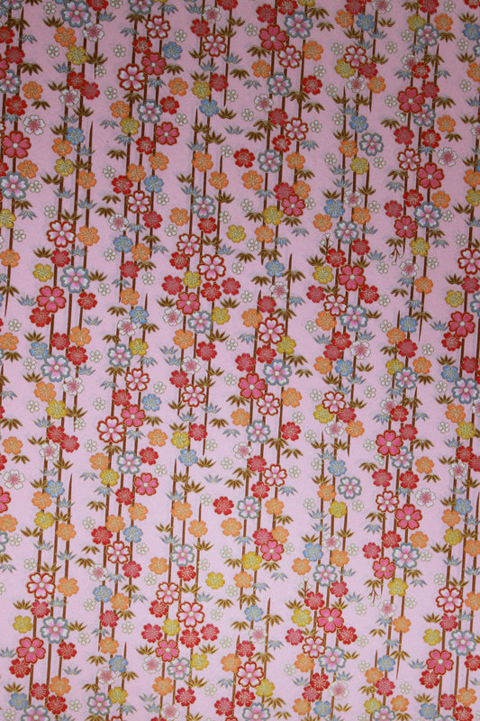 Floral patterned chiyogami paper with small flowers and leaves on a pink background