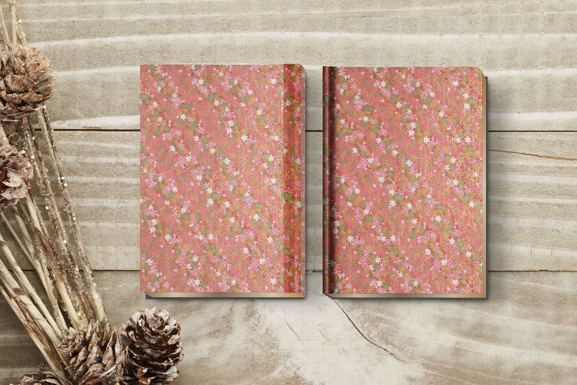 Two floral-patterned notebooks on a wooden surface with decorative elements.