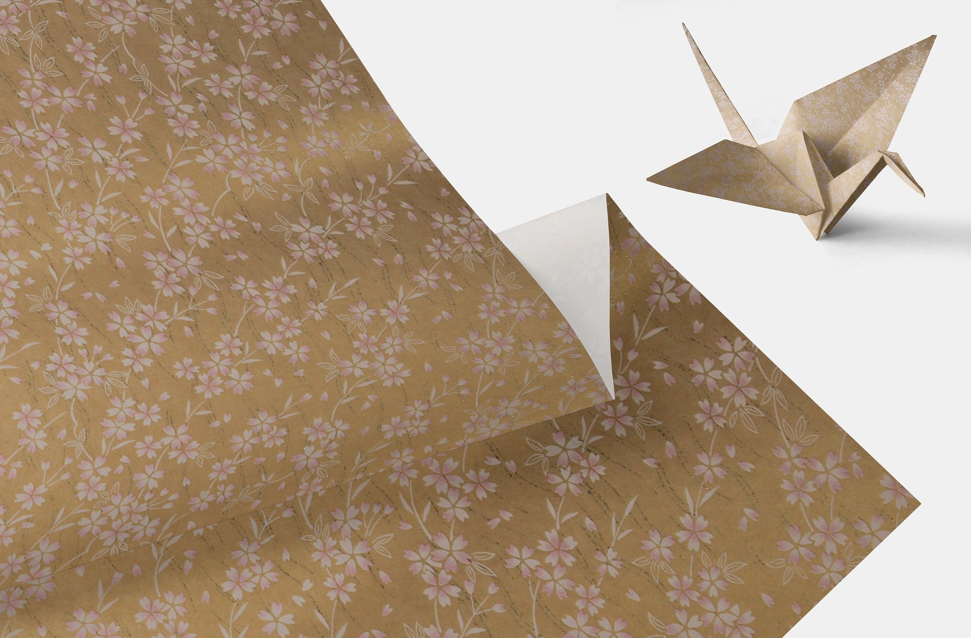 Floral-patterned chiyogami paper with an origami crane on a white background