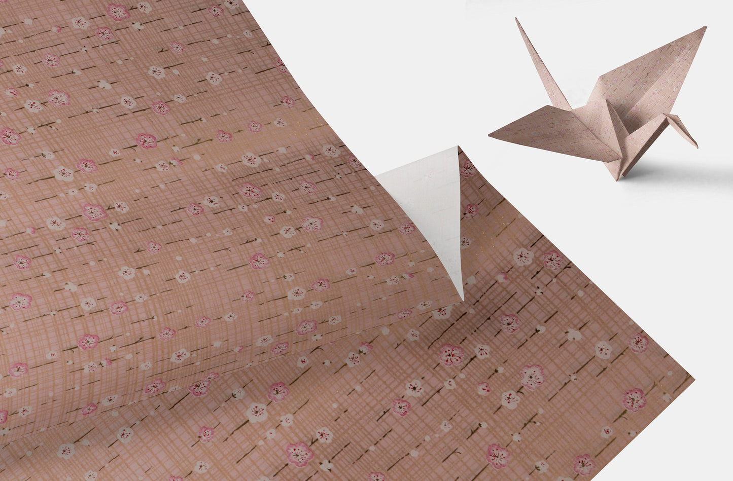 light pink floral-patterned chiyogami paper with a folded origami crane on a light gray background