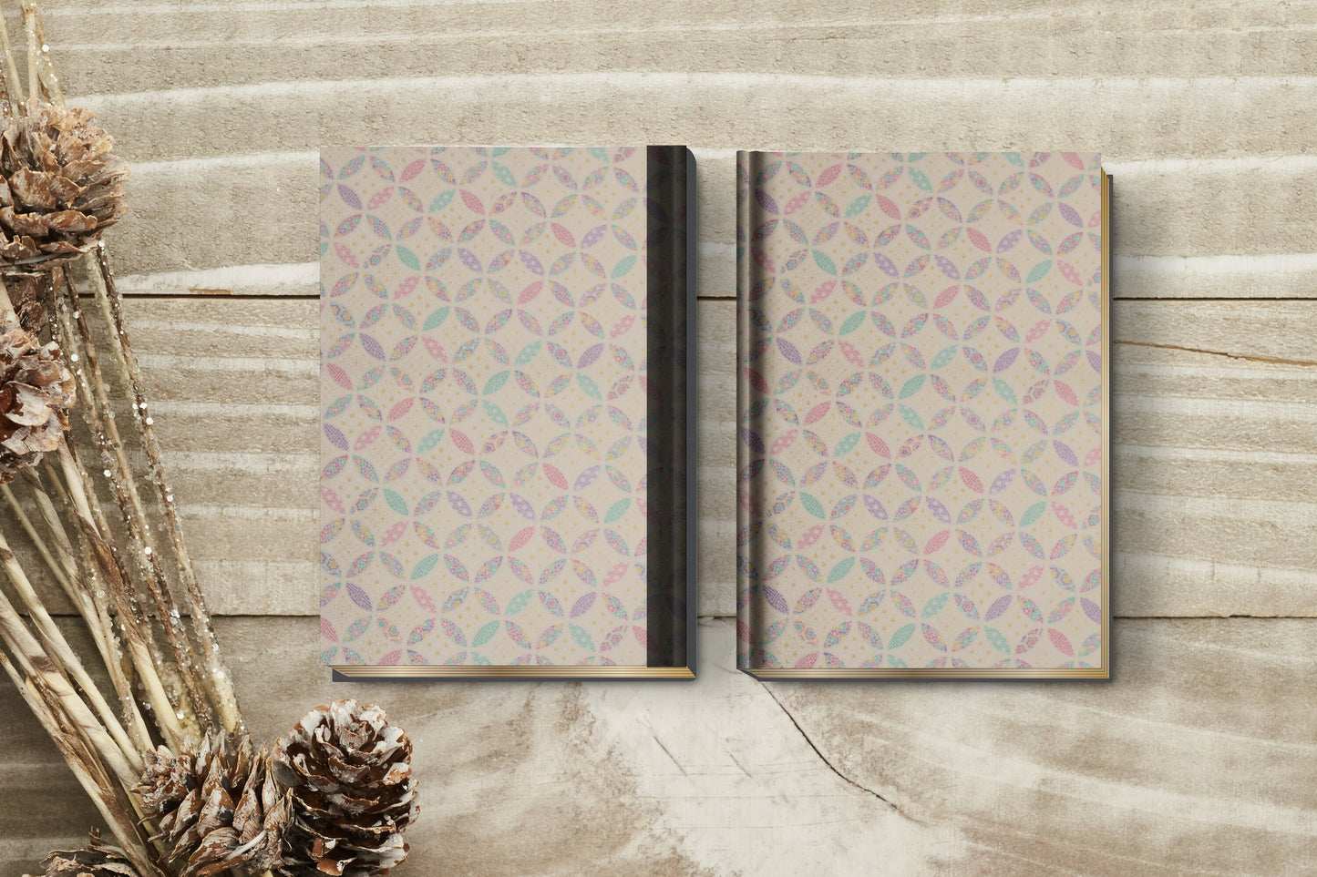 Two patterned notebooks made with chiyogami paper in a bookbinding project  on a wooden surface with decorative elements.