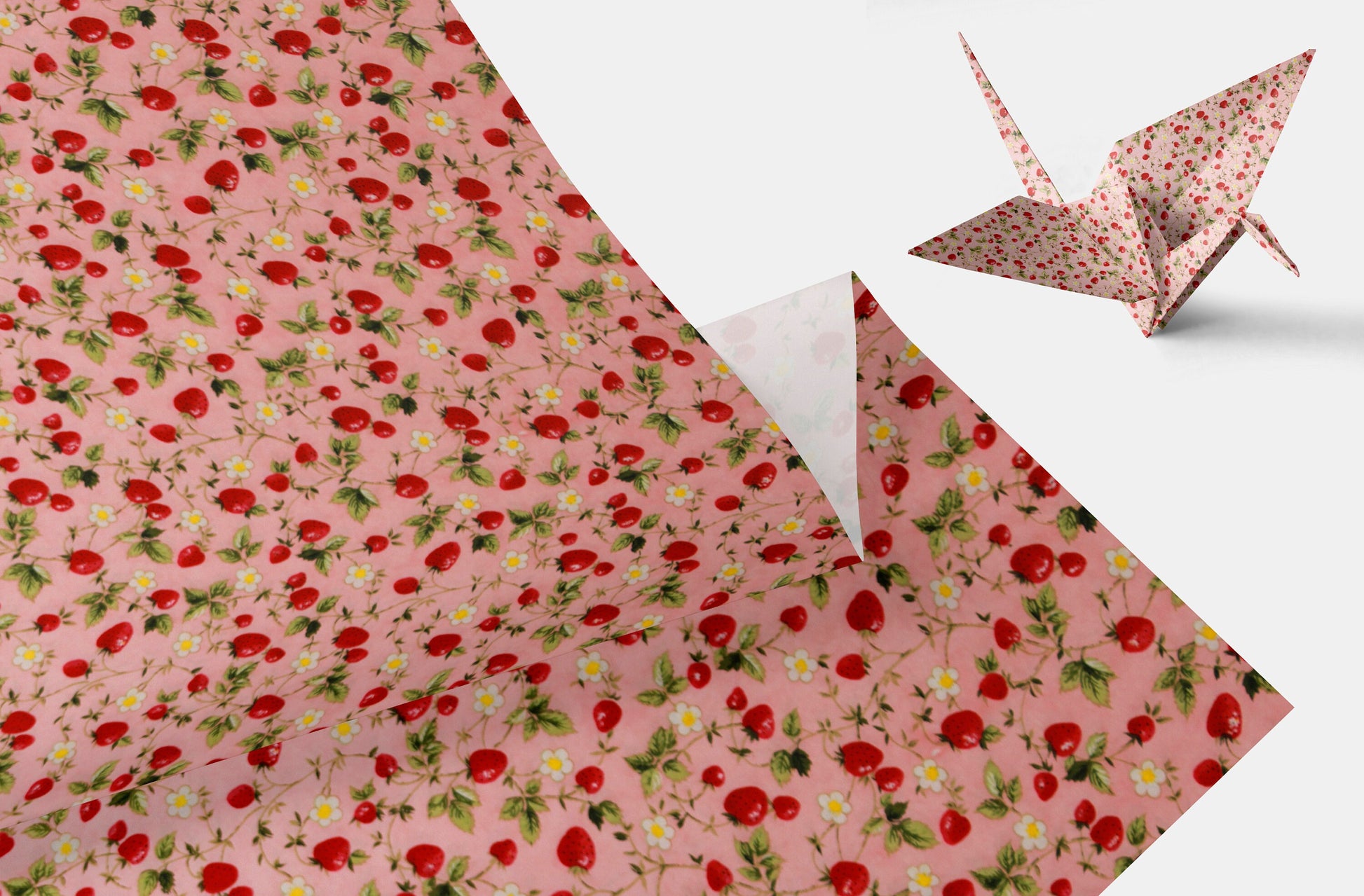 Floral-patterned paper with a folded paper crane on a white background