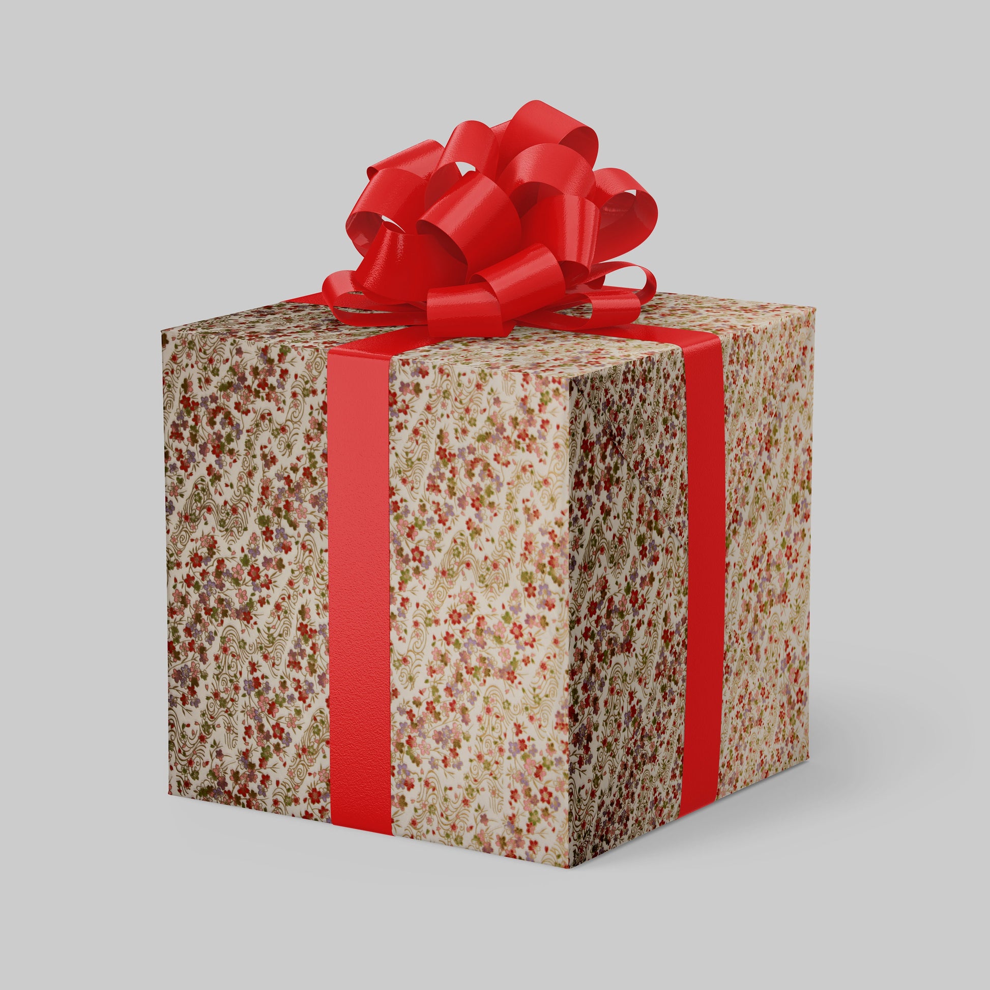 Gift box wrapped with chiyogami paper with floral pattern and red ribbon on a gray background