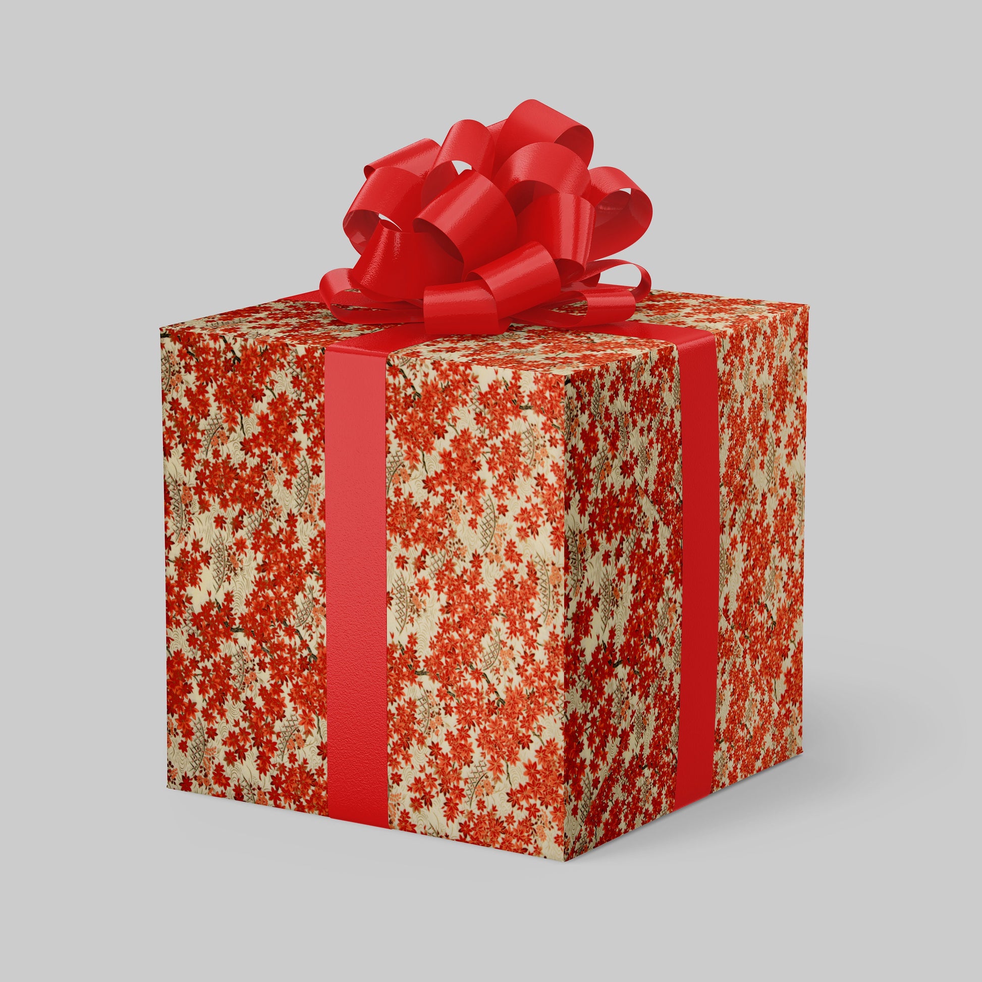 Gift box wrapped with chiyogami paper with red floral pattern and large red bow on a light gray background