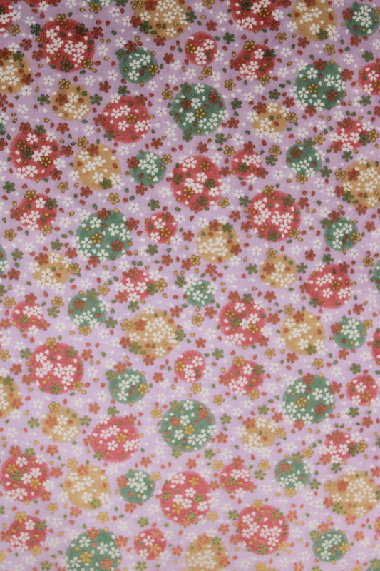 Floral patterned chiyogami paper with small flowers in red, yellow, and green on a pink background
