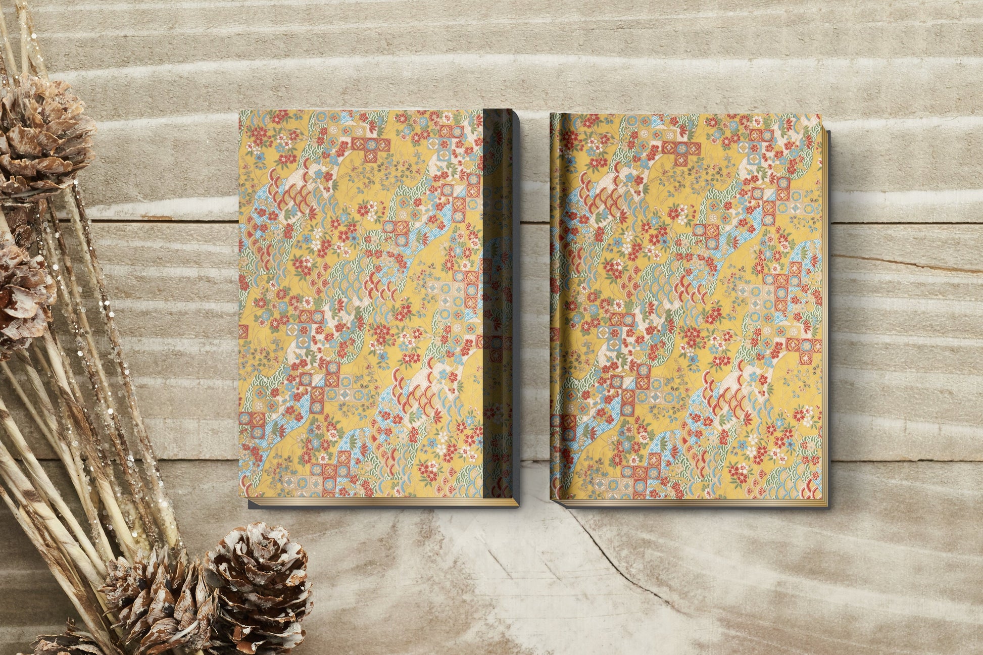 Two decorative books with a floral pattern on a wooden surface.