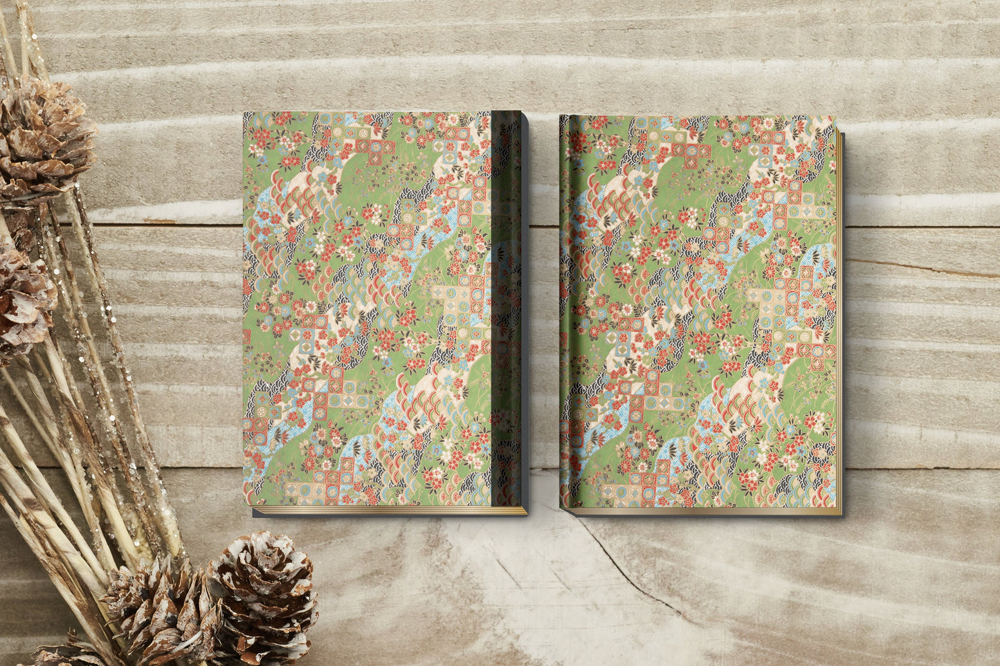 Two floral-patterned books made with chiyogami paper in a bookbinding project on a wooden surface with decorative elements.