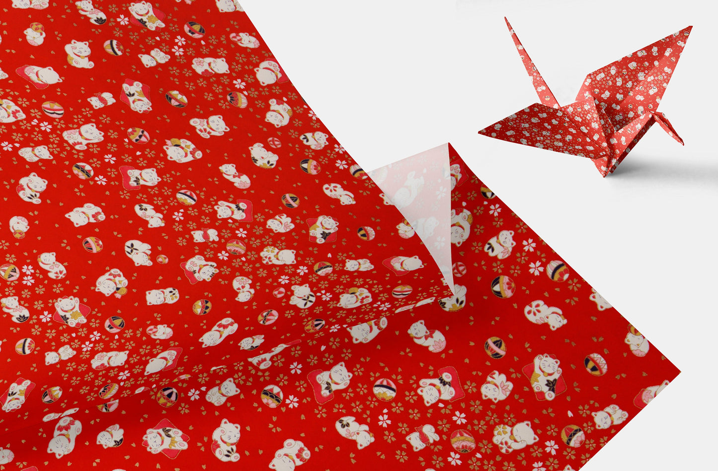 Red wrapping chiyogami paper with white patterns and a folded paper crane on a white background