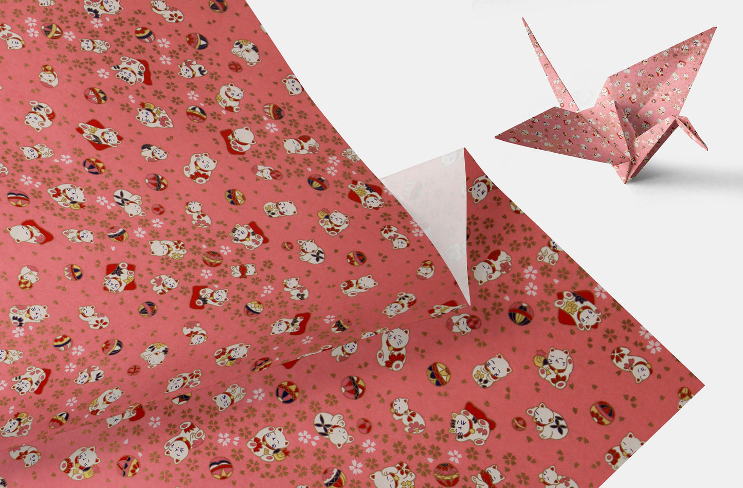 Pink wrapping paper with cartoon characters and a folded paper crane on a white background