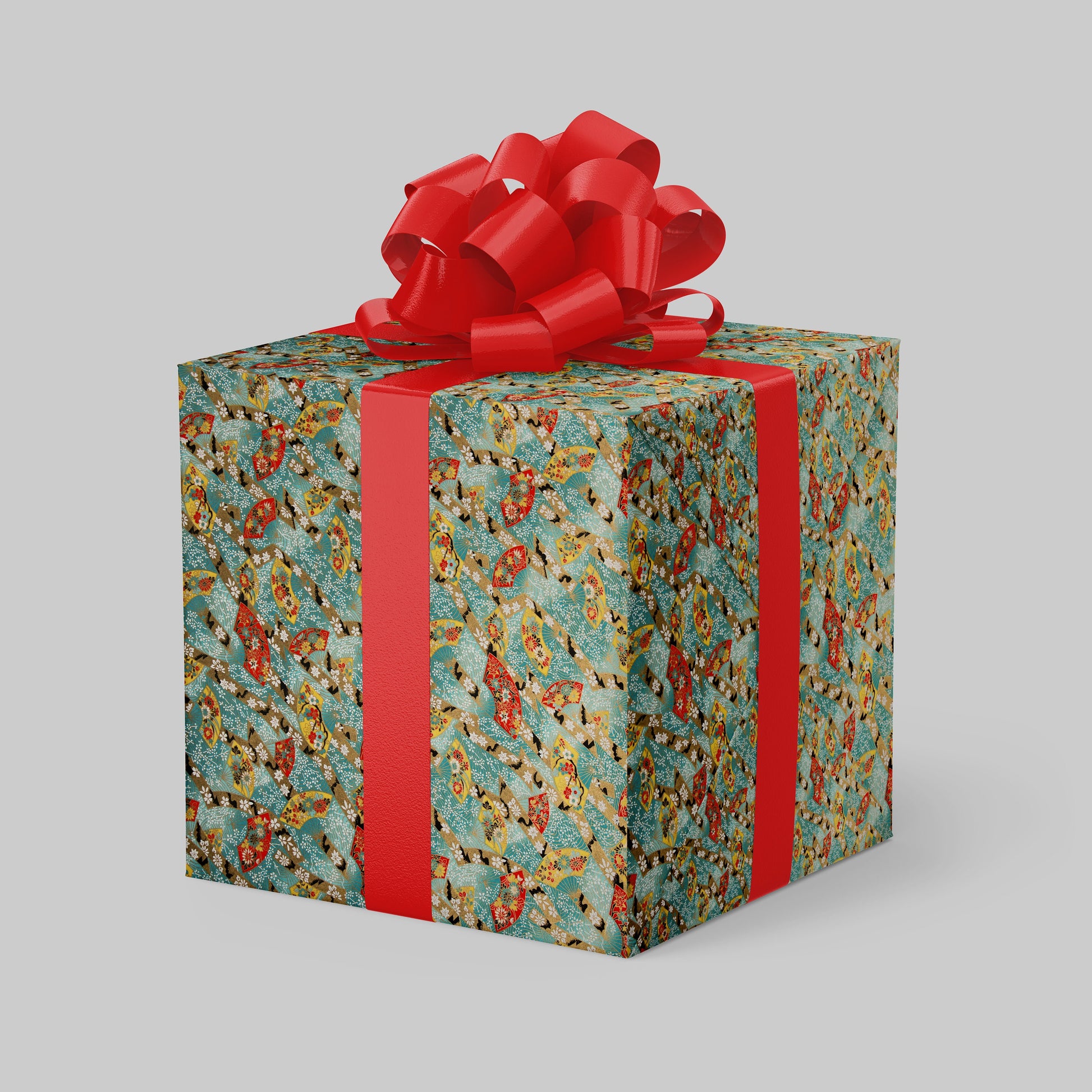 Gift box wrapped with chiyogami paper with floral pattern and red ribbon on a gray background