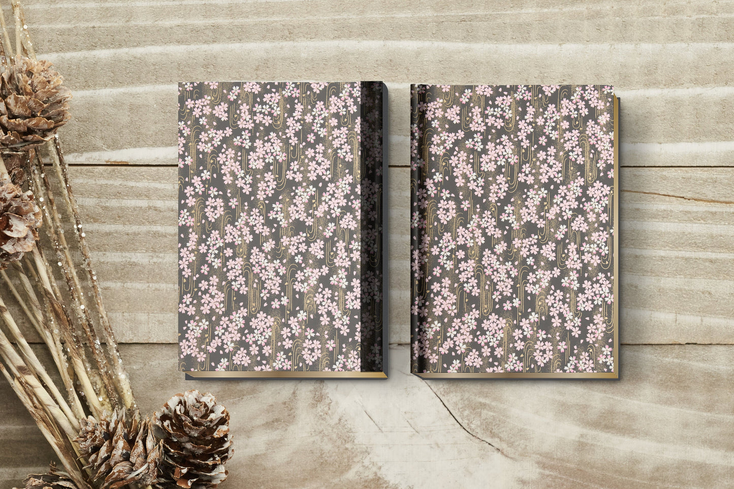 Two floral-patterned notebooks on a wooden surface with decorative elements.