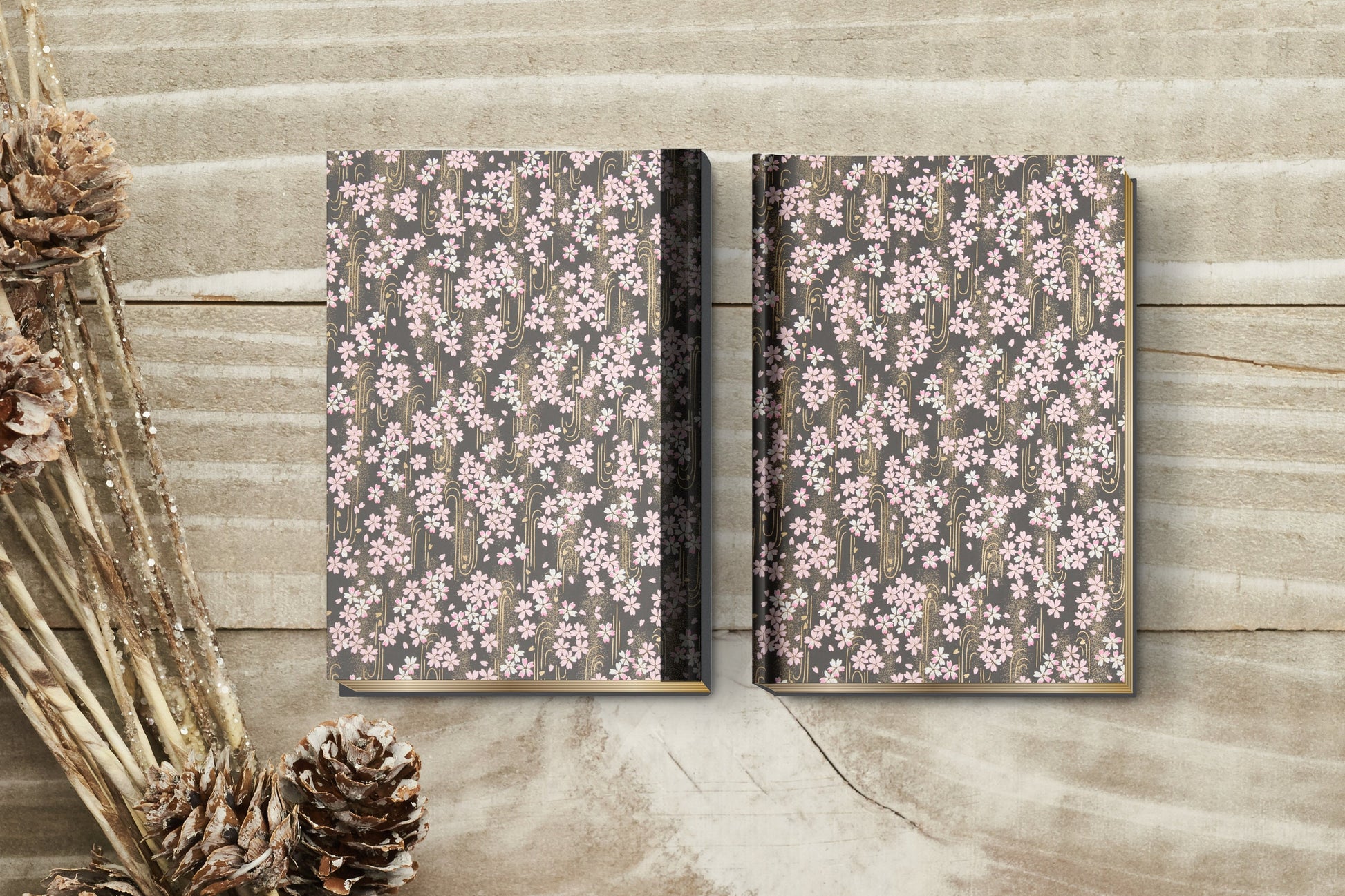 Two floral-patterned notebooks on a wooden surface with decorative elements.