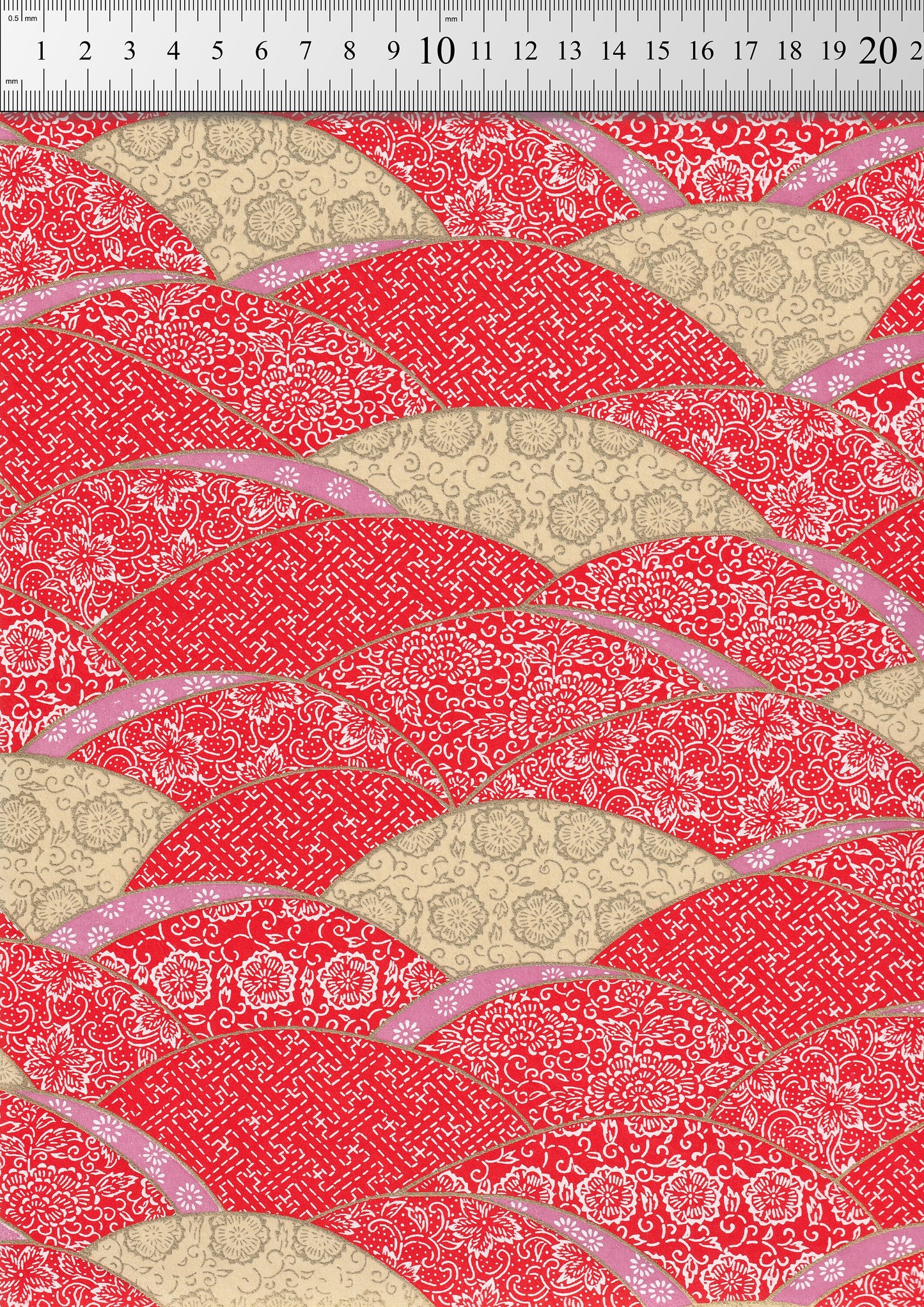 Red and beige patterned  chiyogami paper  with a ruler at the top