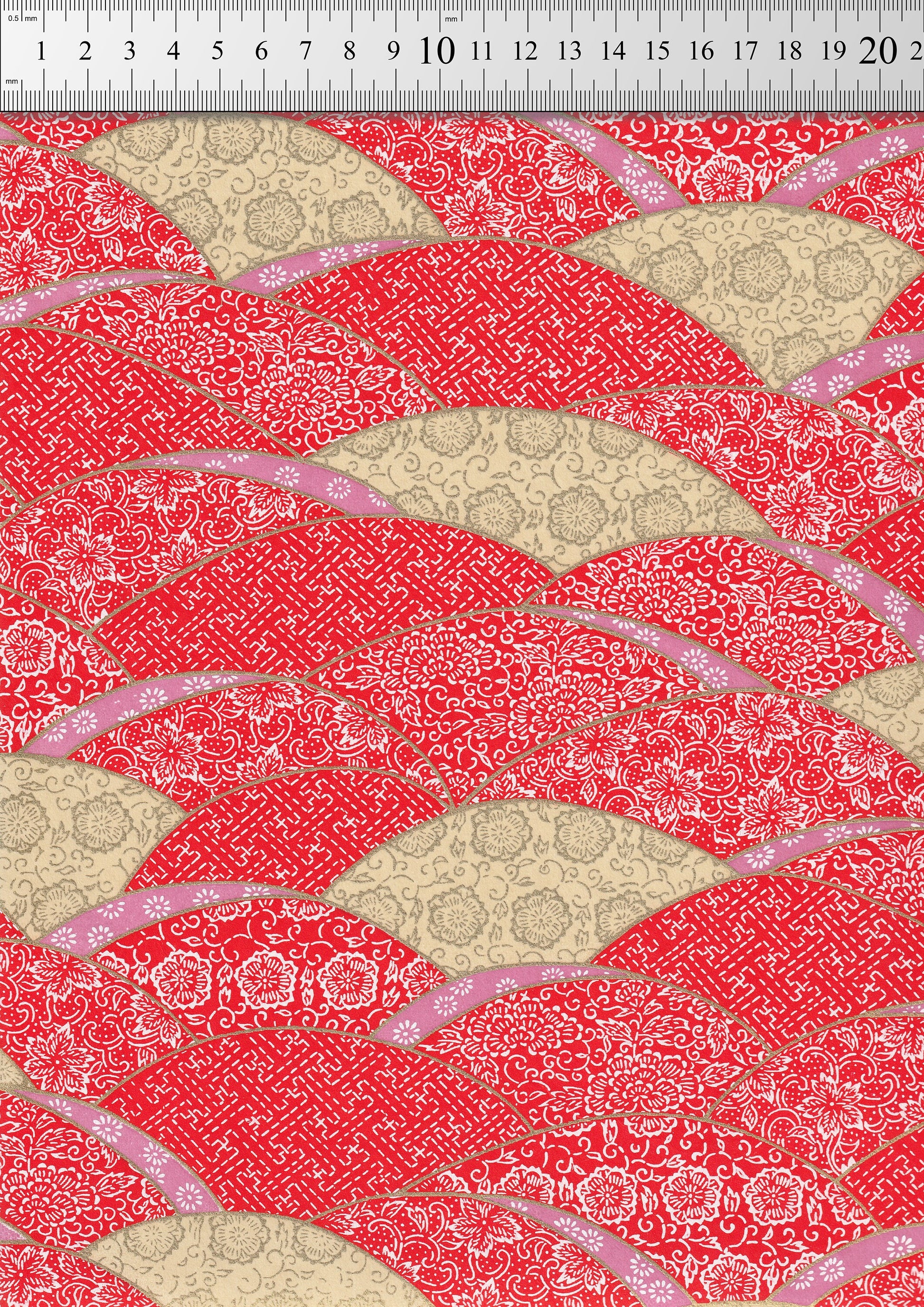 Red and beige patterned  chiyogami paper  with a ruler at the top