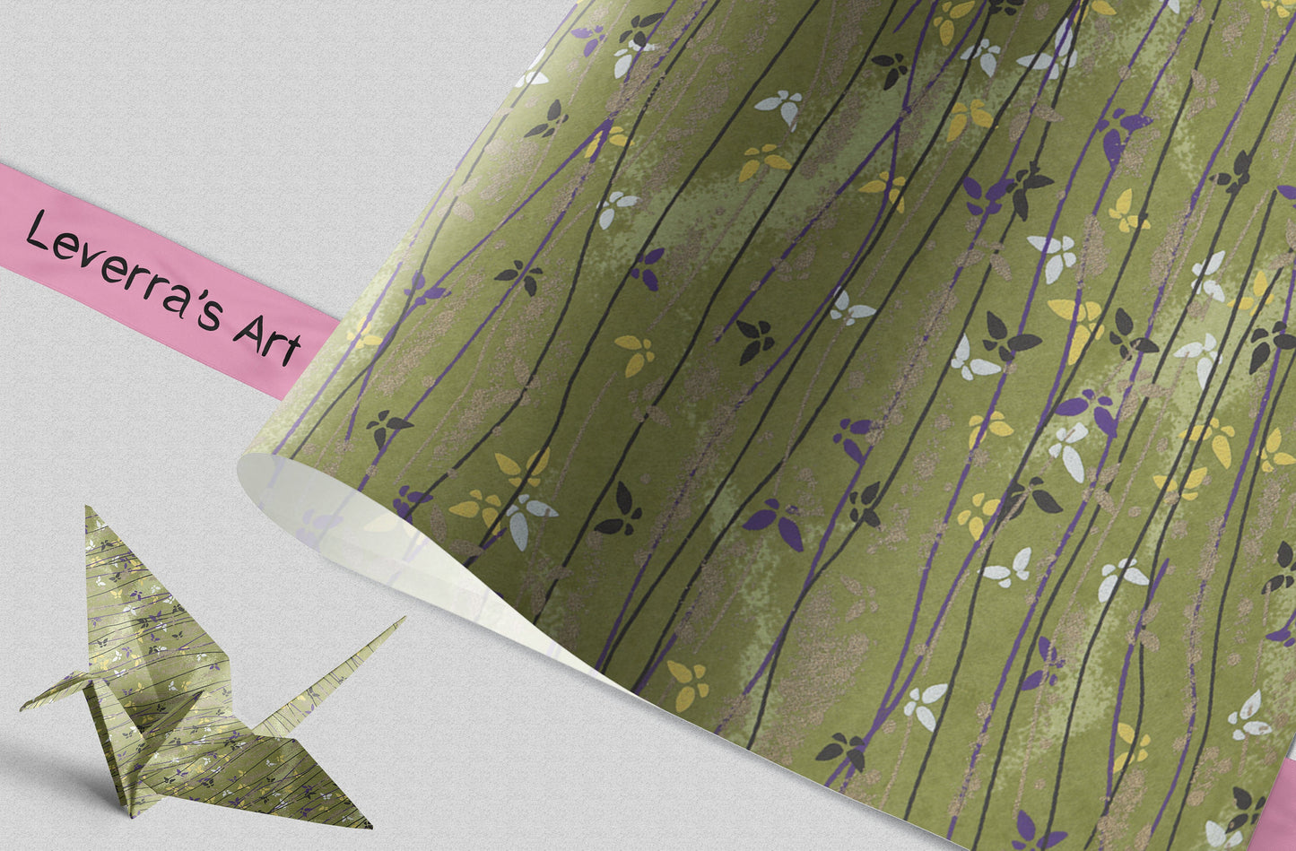 Green floral patterned paper with a folded paper crane and pink label on a light gray background