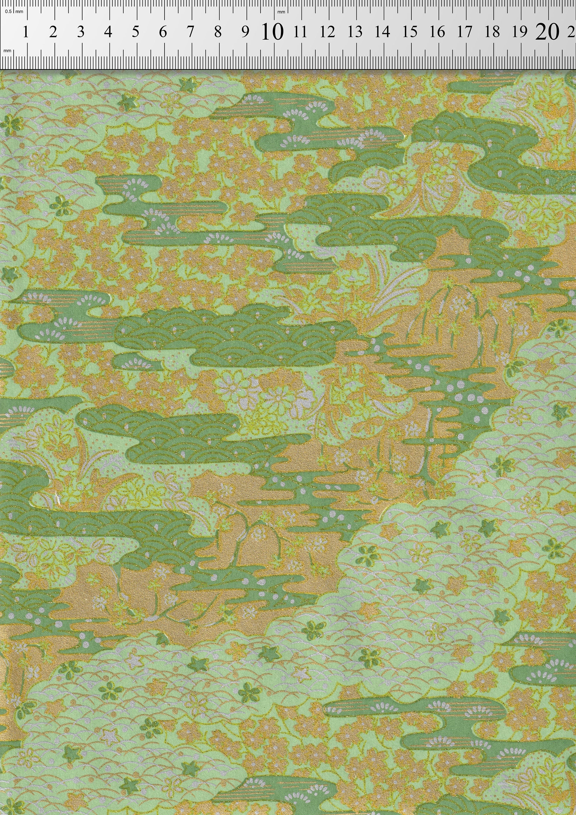Chiyogami paper with green and orange pattern, measured against a ruler