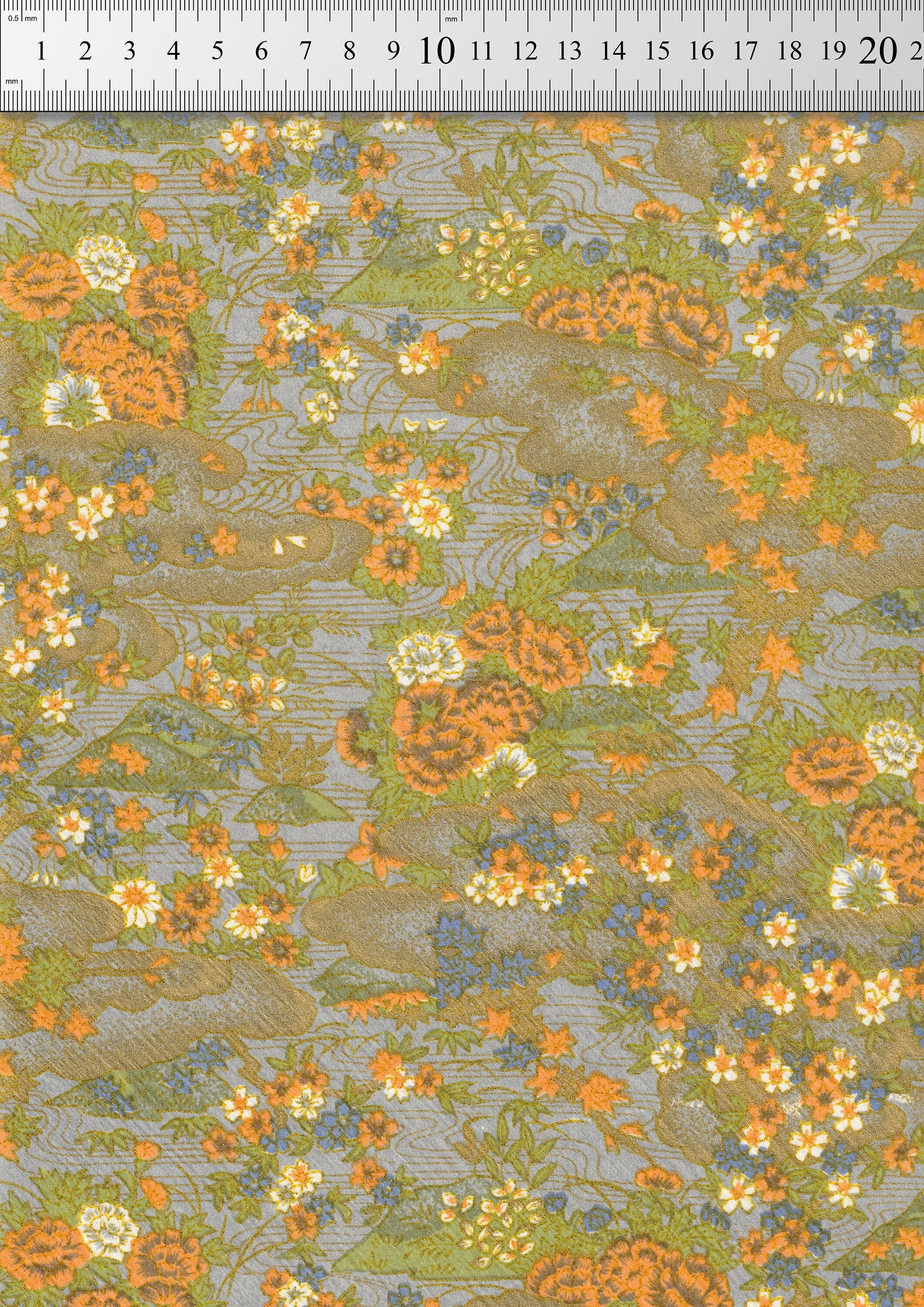 Floral chiyogami paper pattern with orange and green colors on a gray background, measured against a ruler.