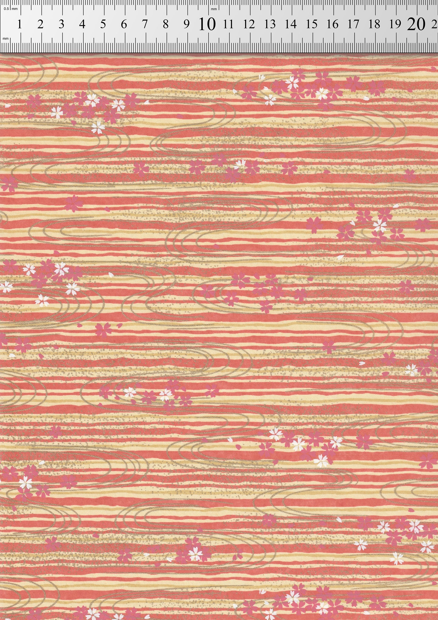 Chiyogami paper with floral pattern and stripes on a red background, measured against a ruler.