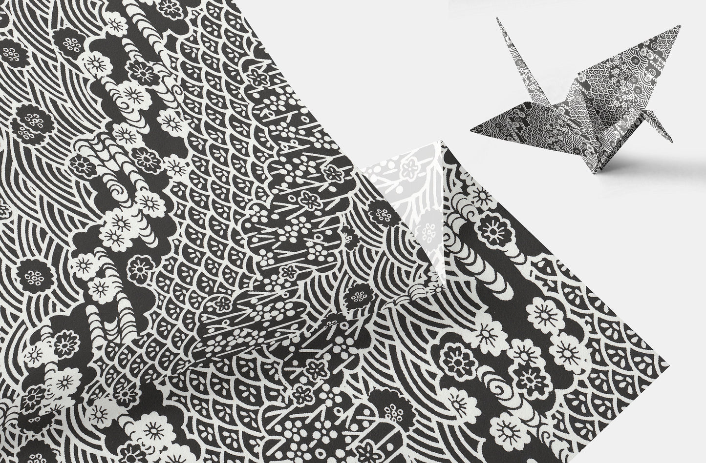 Black and white patterned  chiyogami paper with a folded paper crane on a light gray background