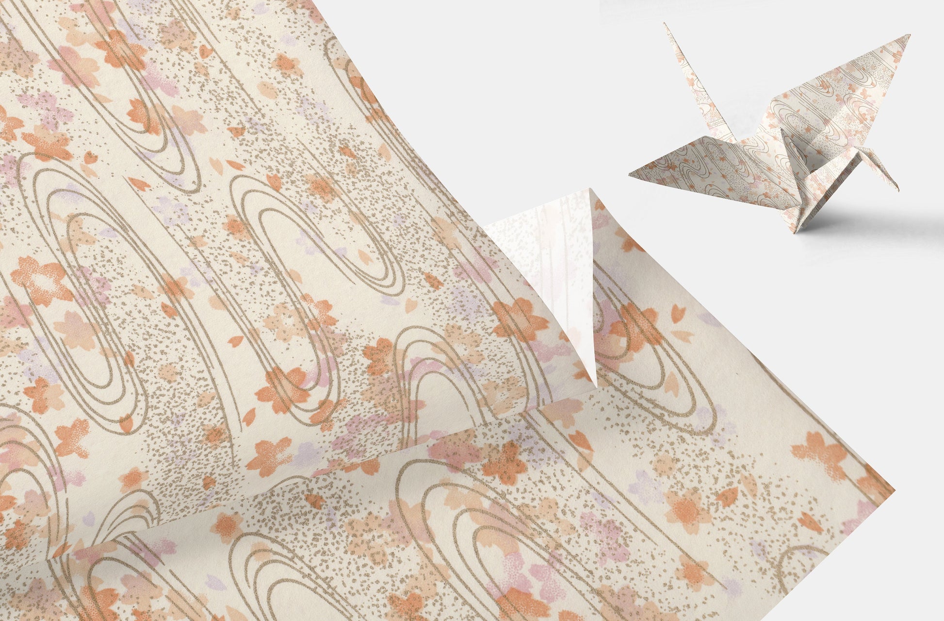 Decorative paper with floral pattern and origami crane on a light background