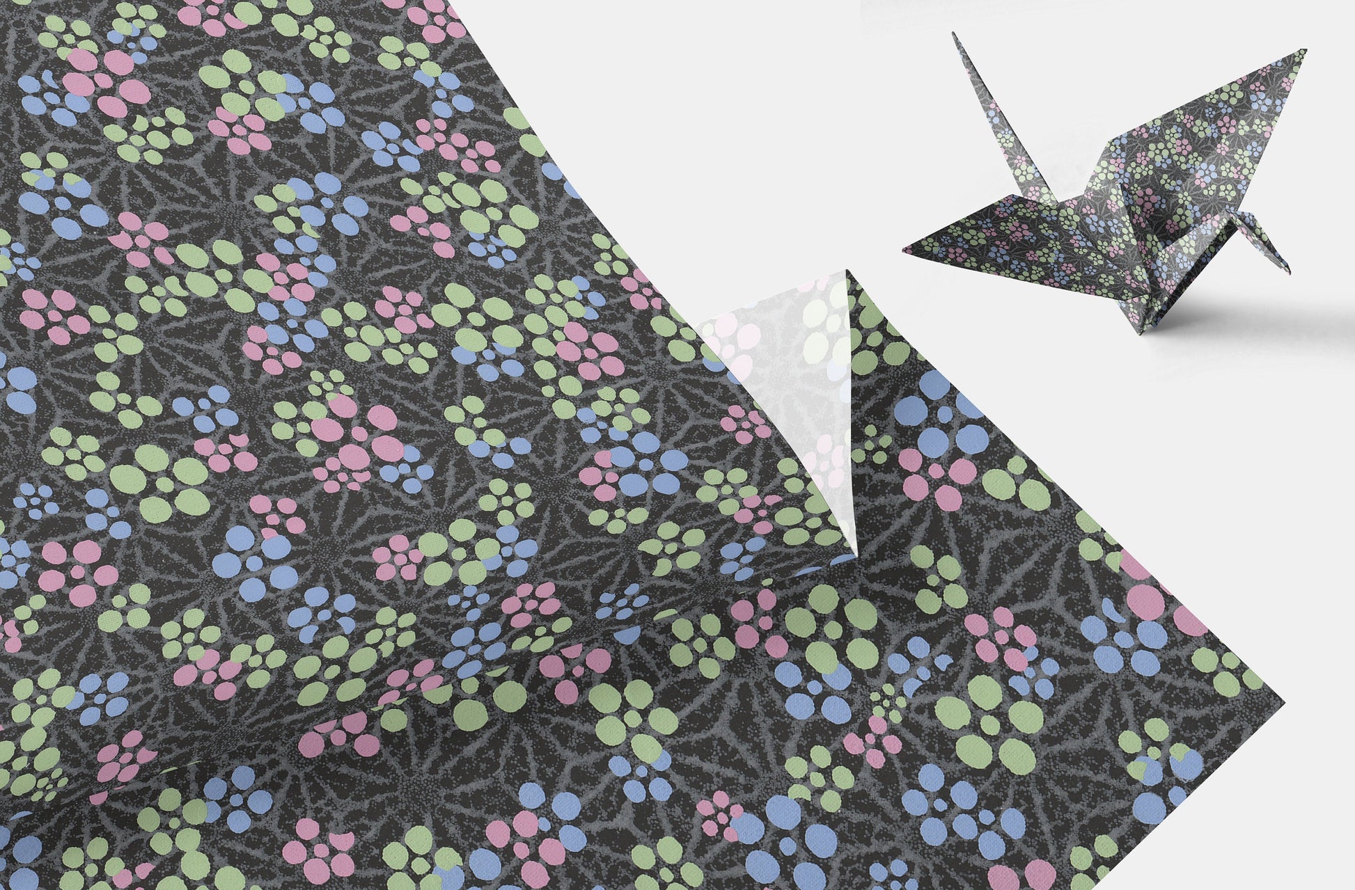 Floral-patterned paper with a folded paper crane on a white background