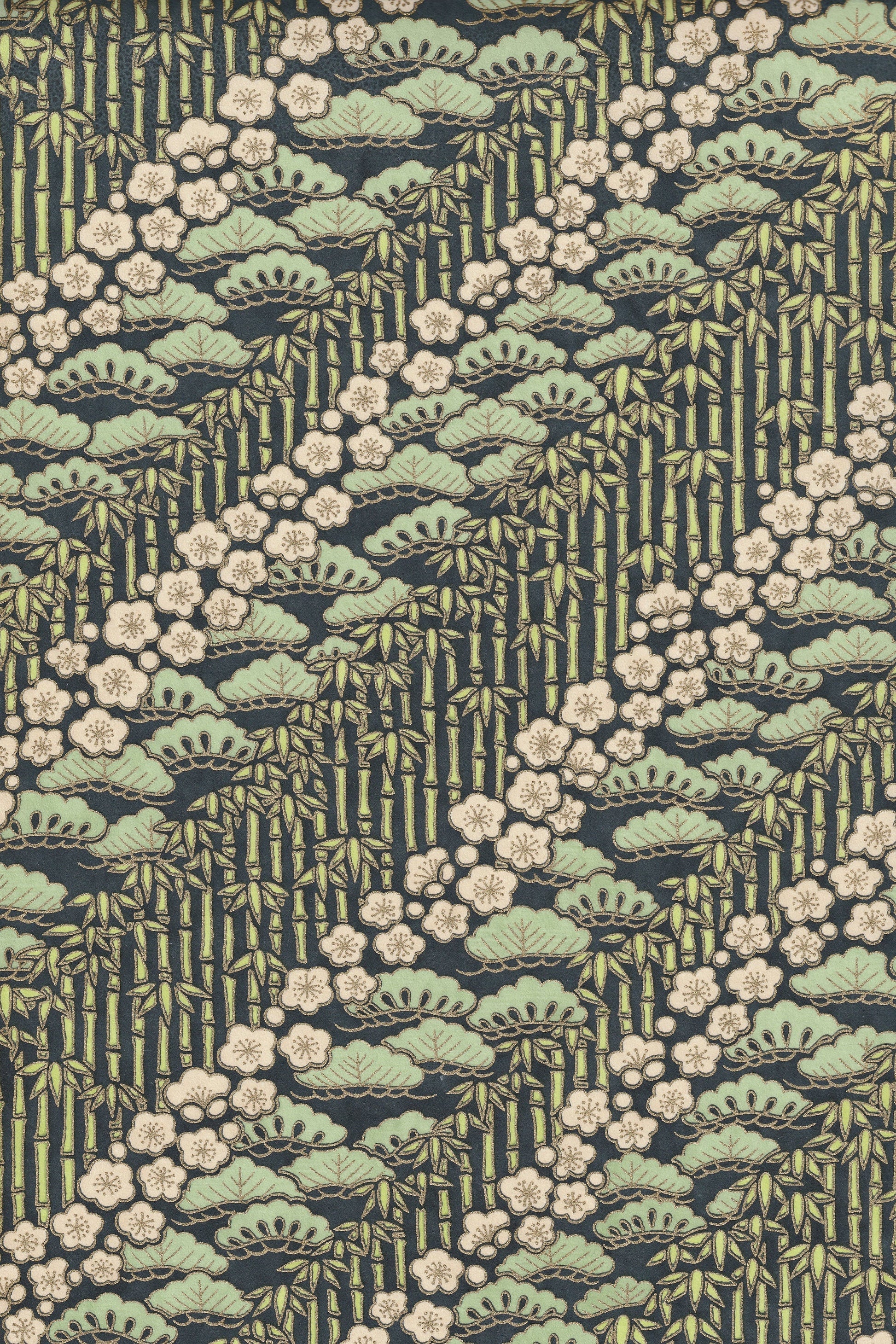 Patterned chiyogami paper with green and beige design on a dark background