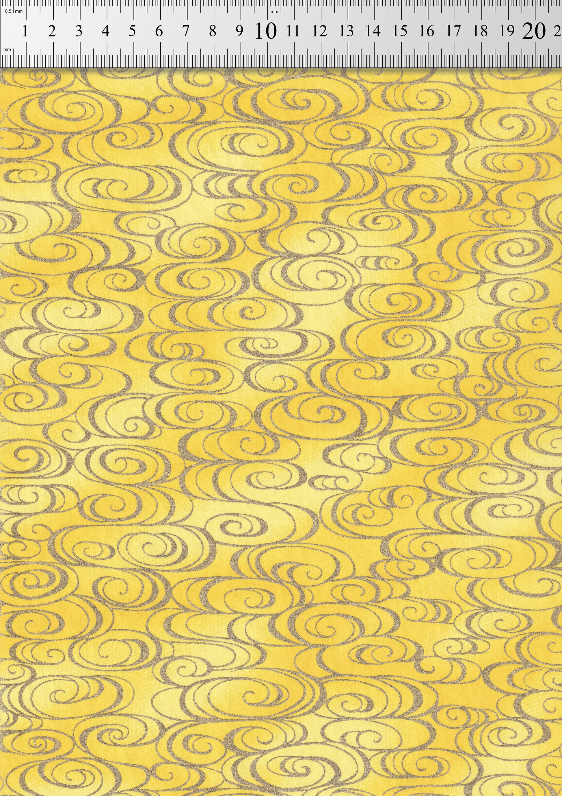 Chiyogami Paper with grey swirl patterns on yellow background with a ruler as scale