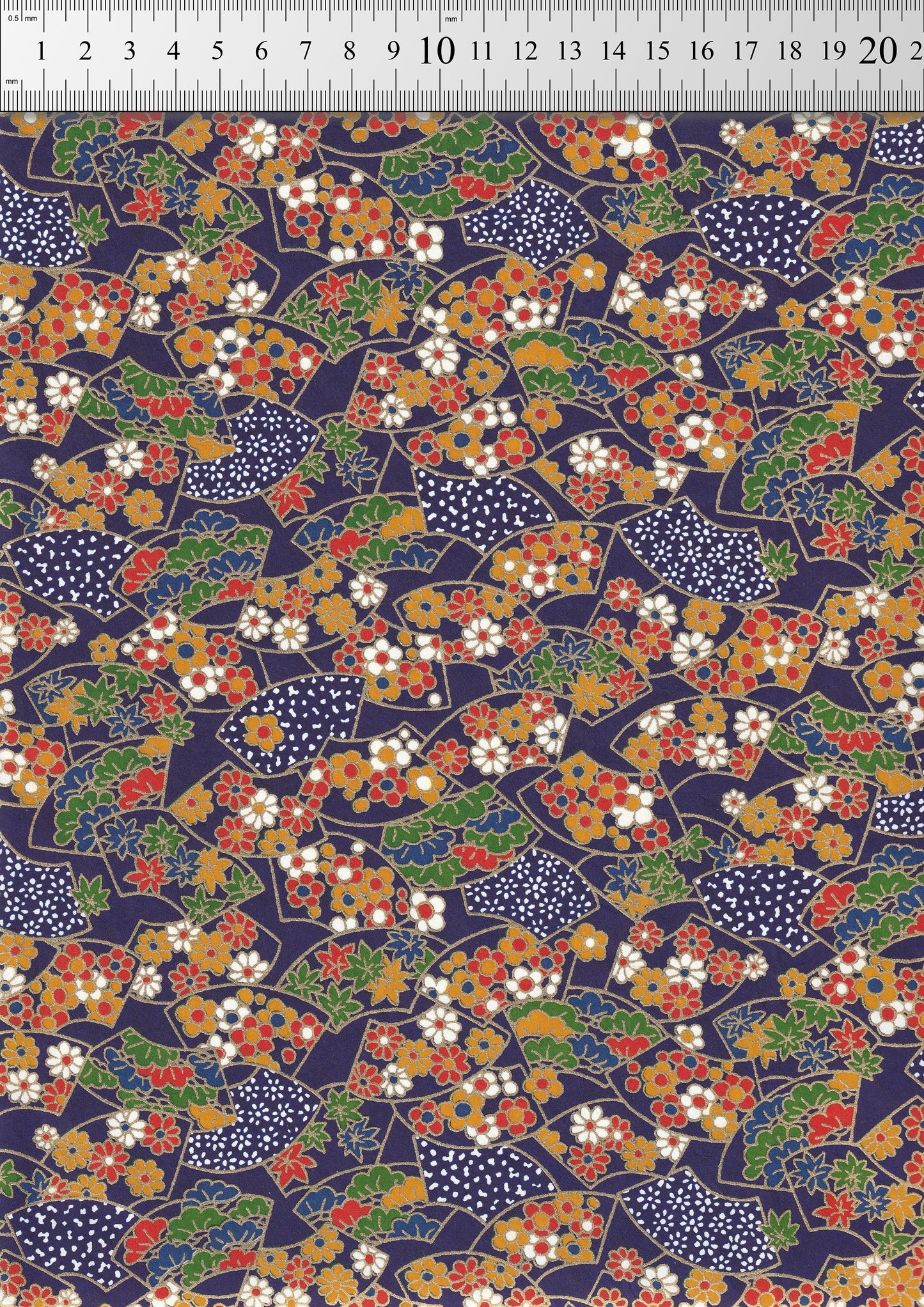 Colorful floral pattern on a dark blue background with a ruler for scale.