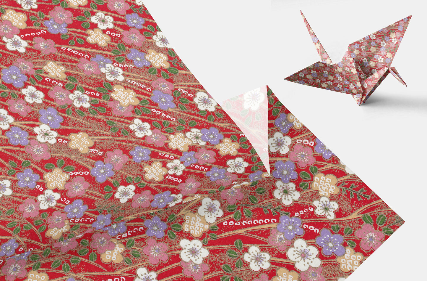 Decorative chiyogami paper with floral pattern and a folded paper crane on a white background