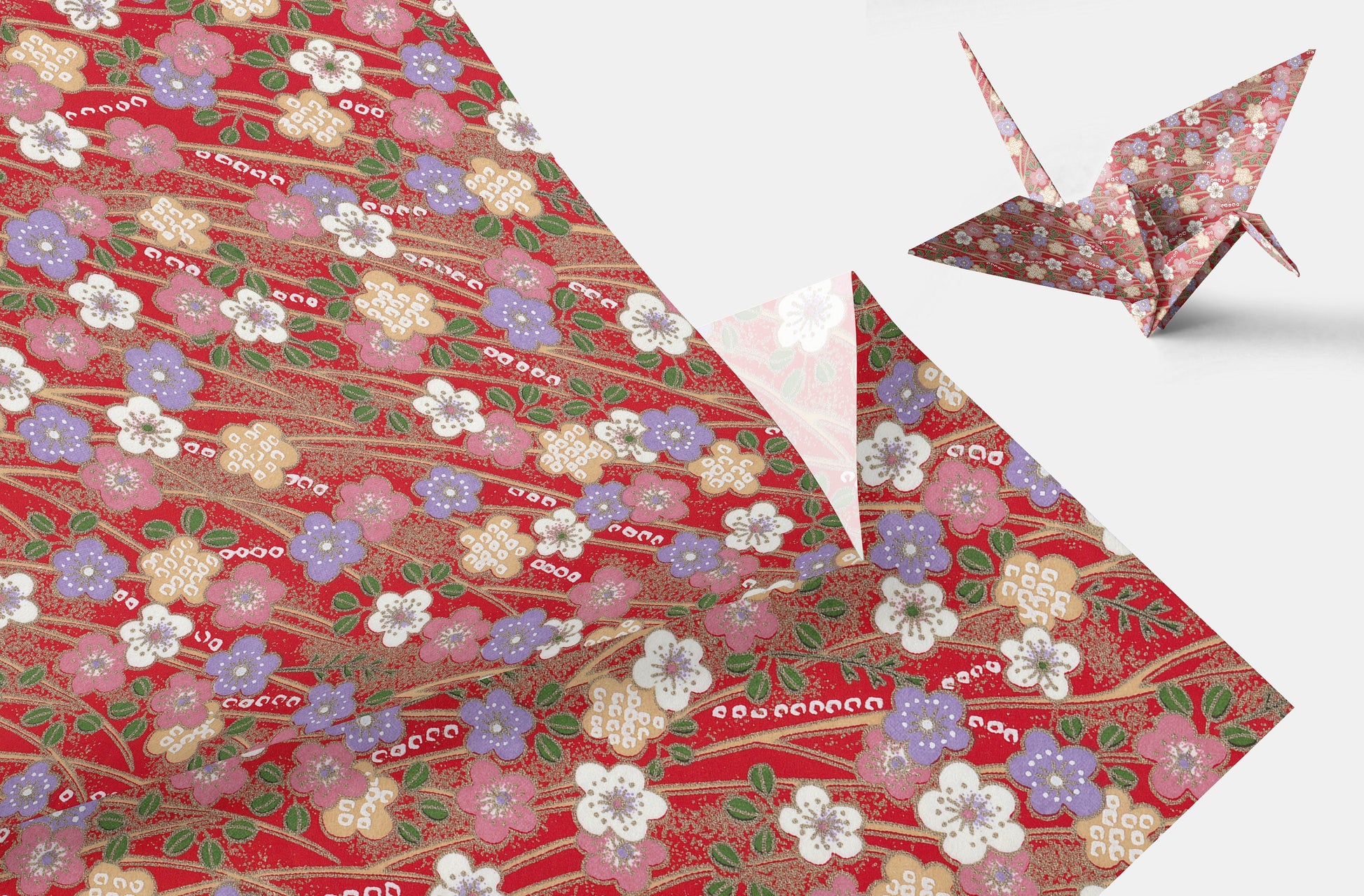 Decorative chiyogami paper with floral pattern and a folded paper crane on a white background