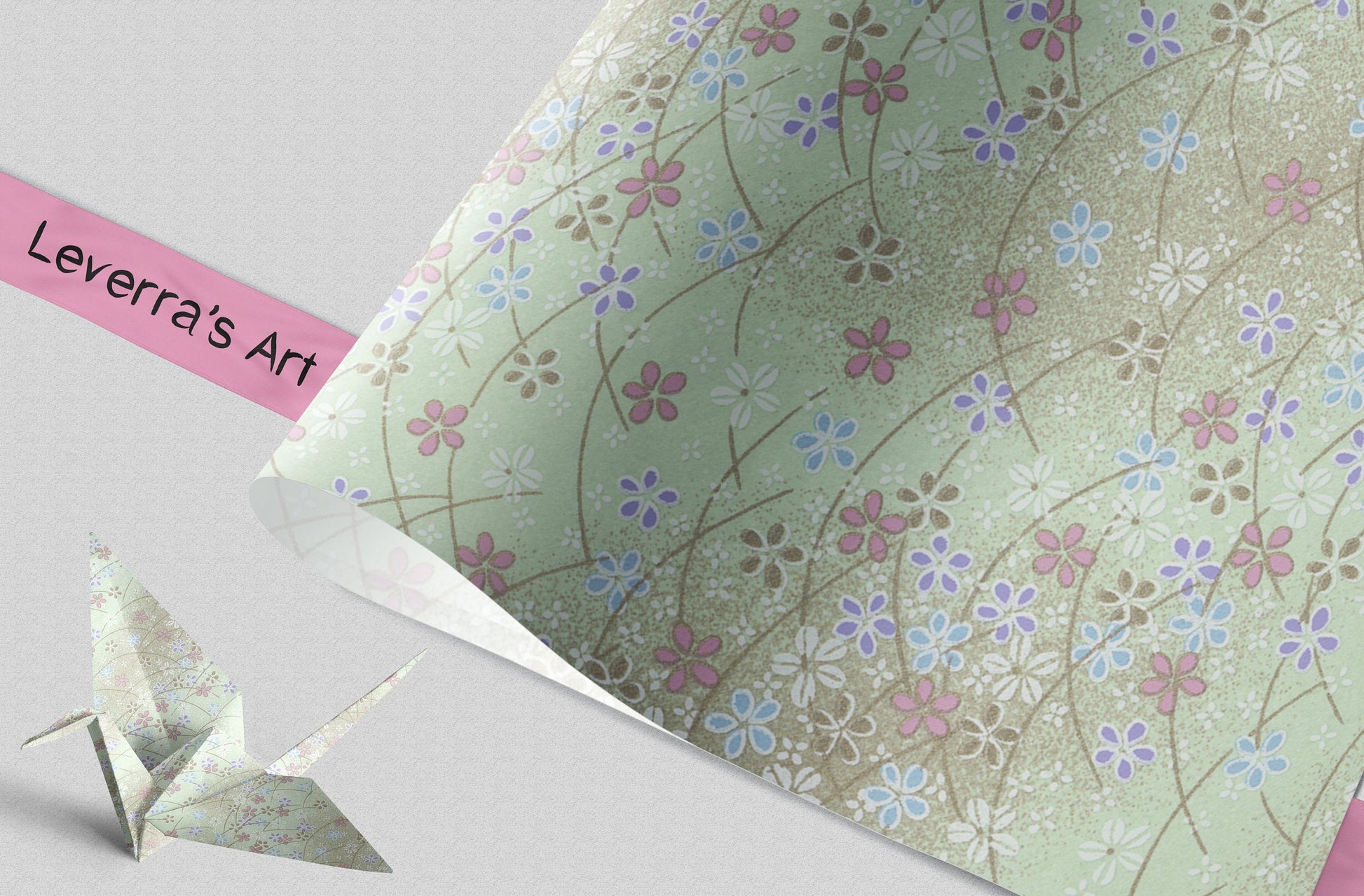 Floral patterned paper with a pink ribbon and origami crane on a light gray background