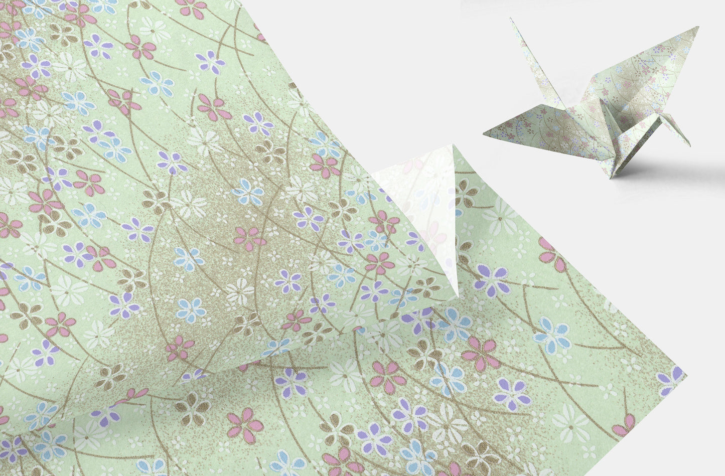 Floral-patterned paper with a folded paper crane on a light background