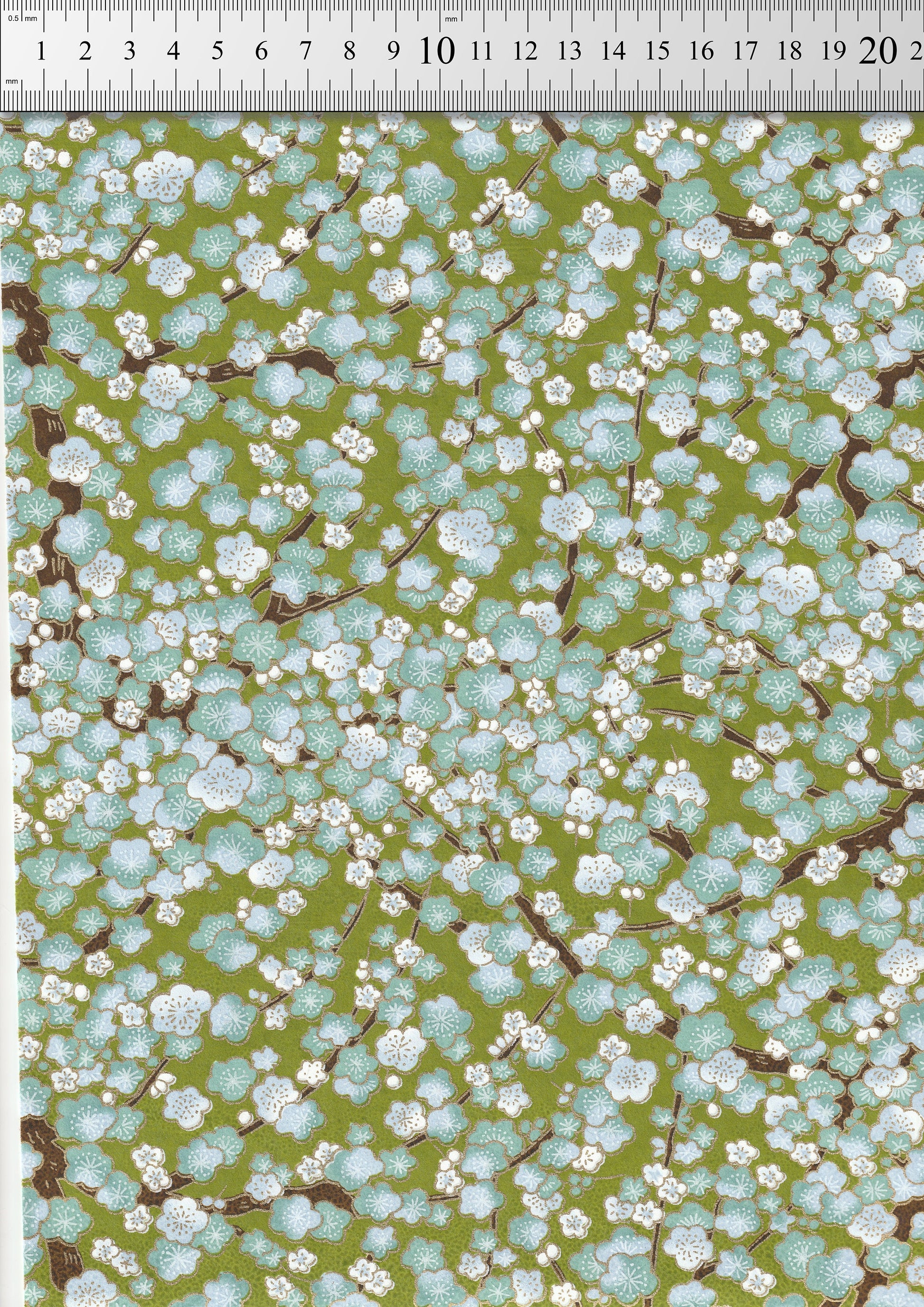Floral pattern  chiyogami paper with a ruler at the top for scale on a green background
