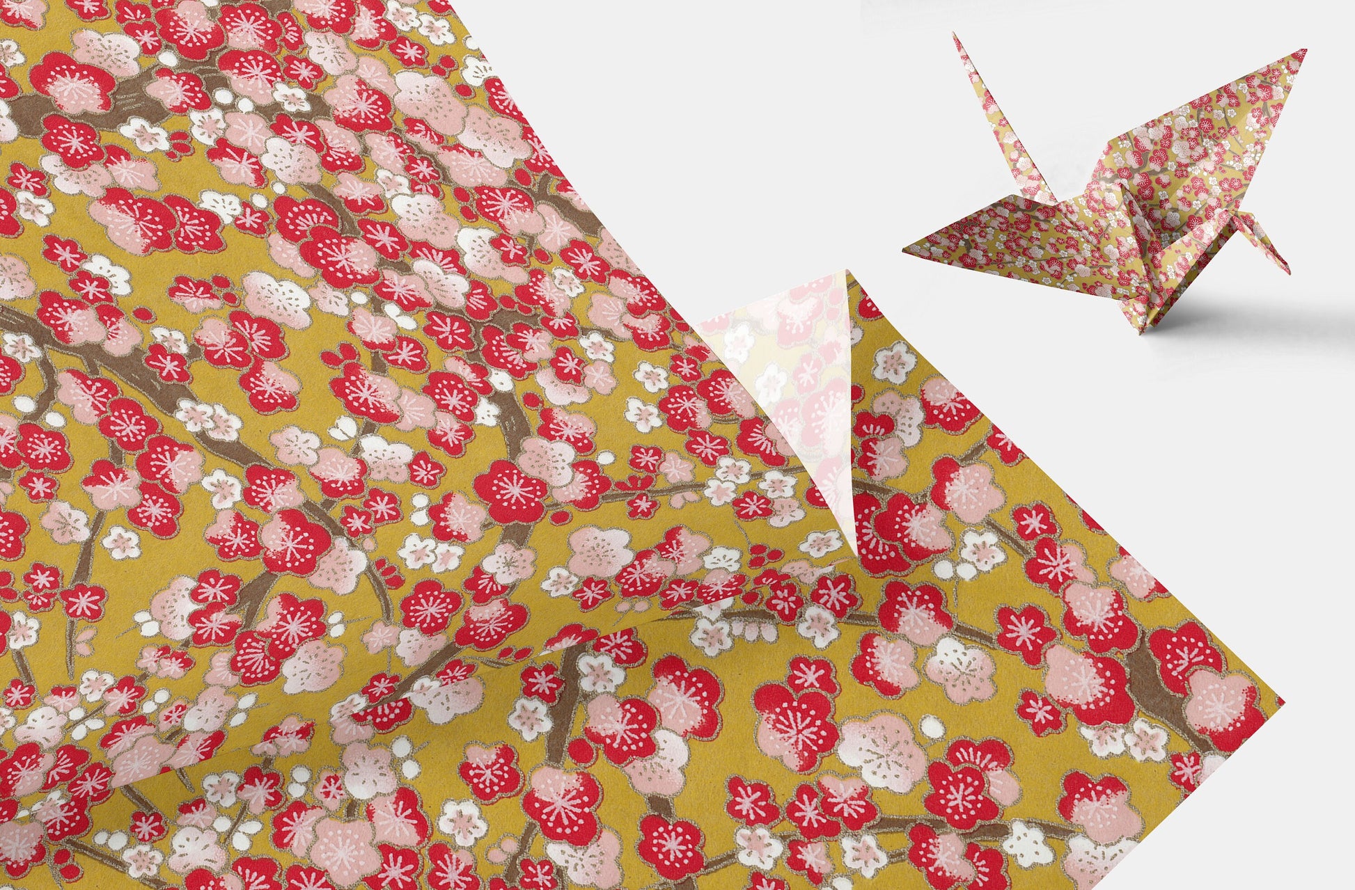 Floral-patterned paper with a folded paper crane on a white background