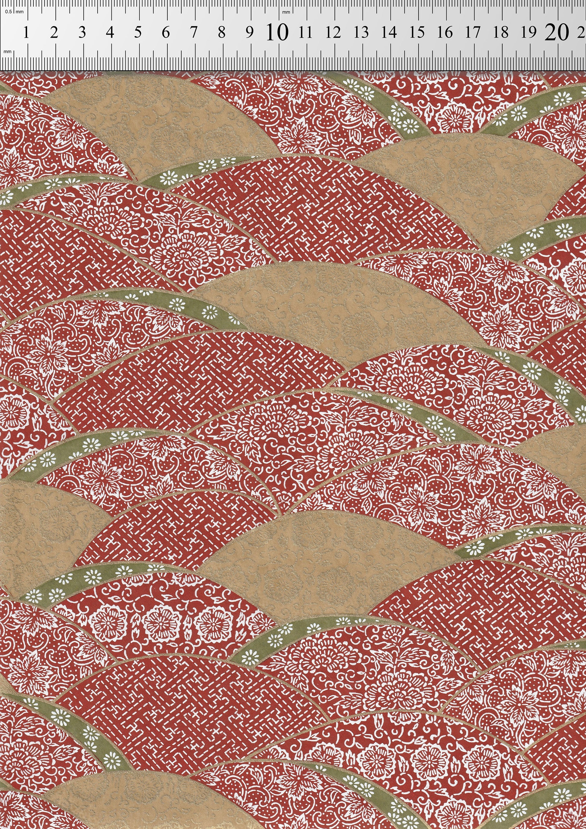 Chiyogami paper with a red and beige pattern, measured against a ruler.