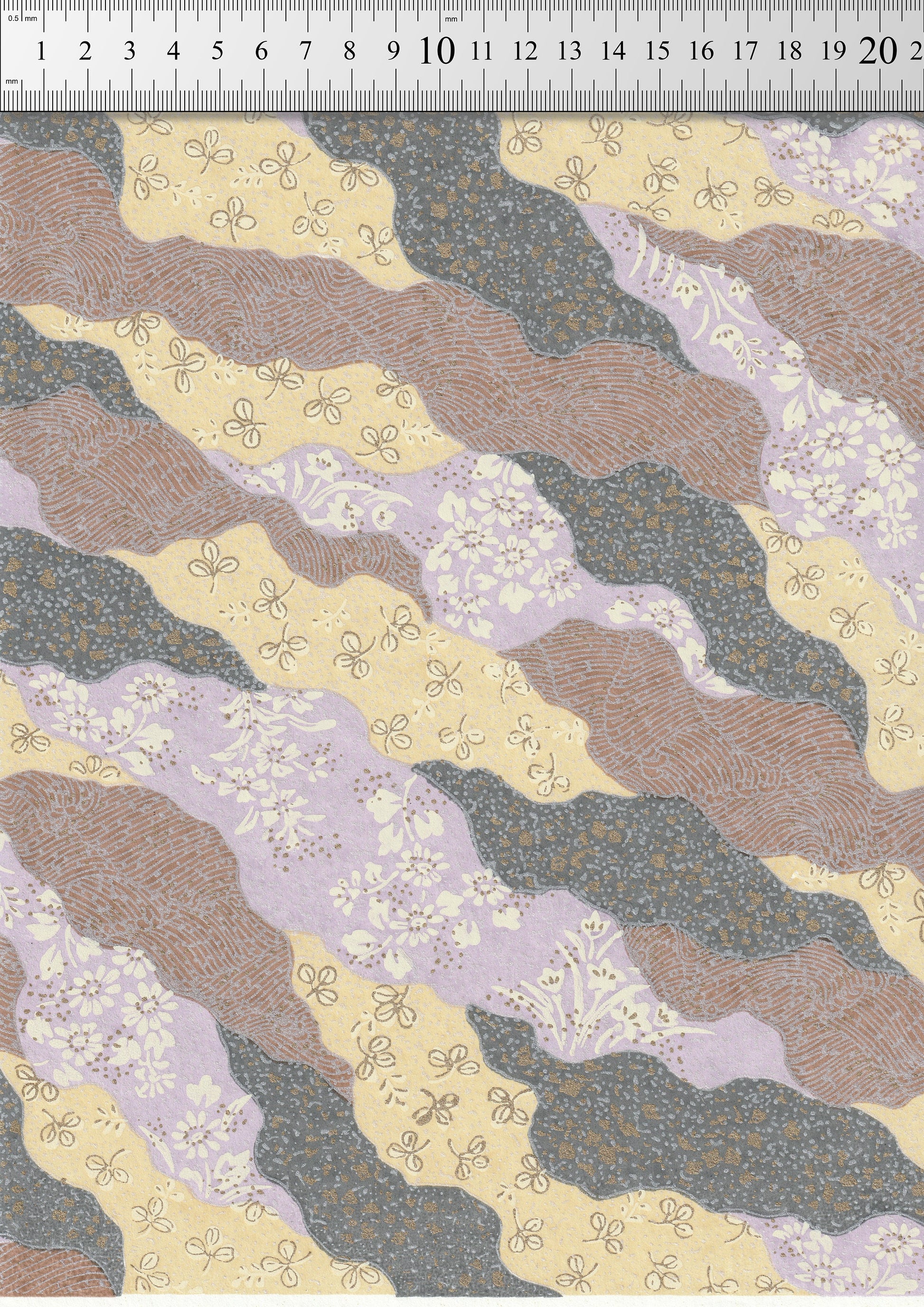 Patterned chiyogami paper with wavy lines and floral designs on a measuring scale background